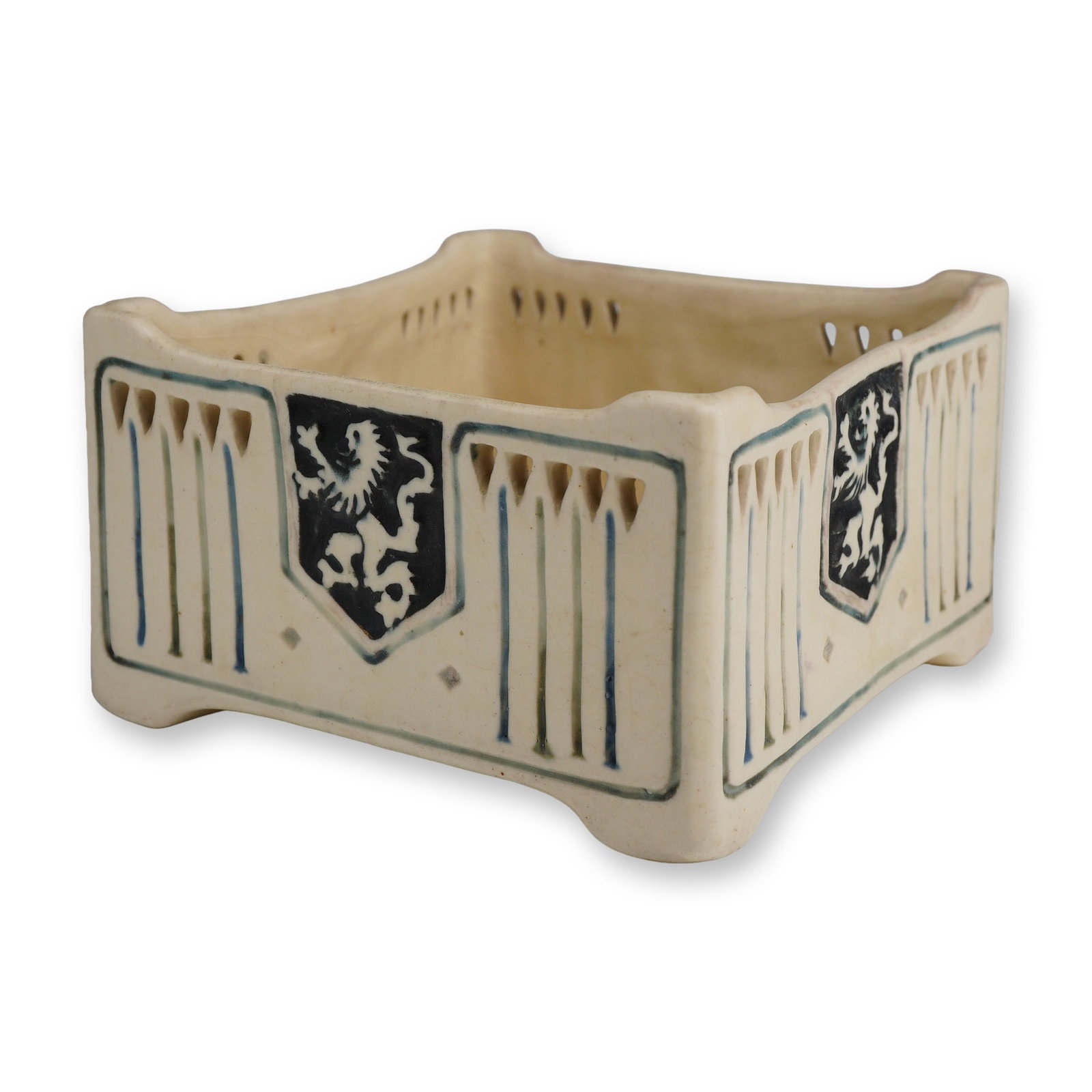 Weller Pottery Creamware Reticulated Square Planter, Ethel: Weller Ethel Creamware ceramic vessel featuring a square, squat form with a matte cream glaze. The exterior is decorated with heraldic-style black shields containing white rampant lions, flanked by ve