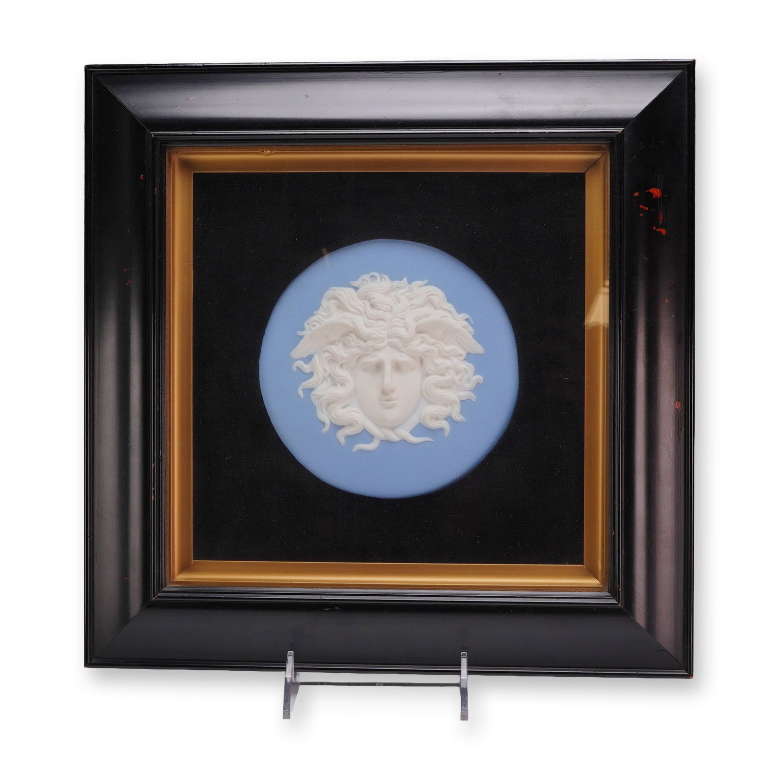 Wedgwood Light Blue Jasperware Medusa Rondanini Plaque: A circular Wedgwood jasperware plaque featuring a high-relief white sprigged decoration of the head of Medusa against a light blue ground. This design is modeled after the Medusa Rondanini, characteri
