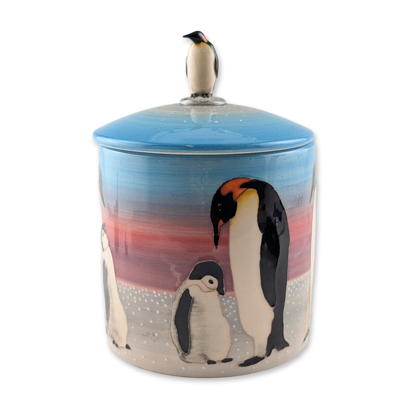 Dennis Chinaworks by Sally Tuffin Penguin Lidded Jar: The cylindrical vessel features a hand-painted scene of Emperor penguins executed with slip-trailed tube-lined outlines. The primary decoration depicts an adult penguin and a chick on a snow-flecked l