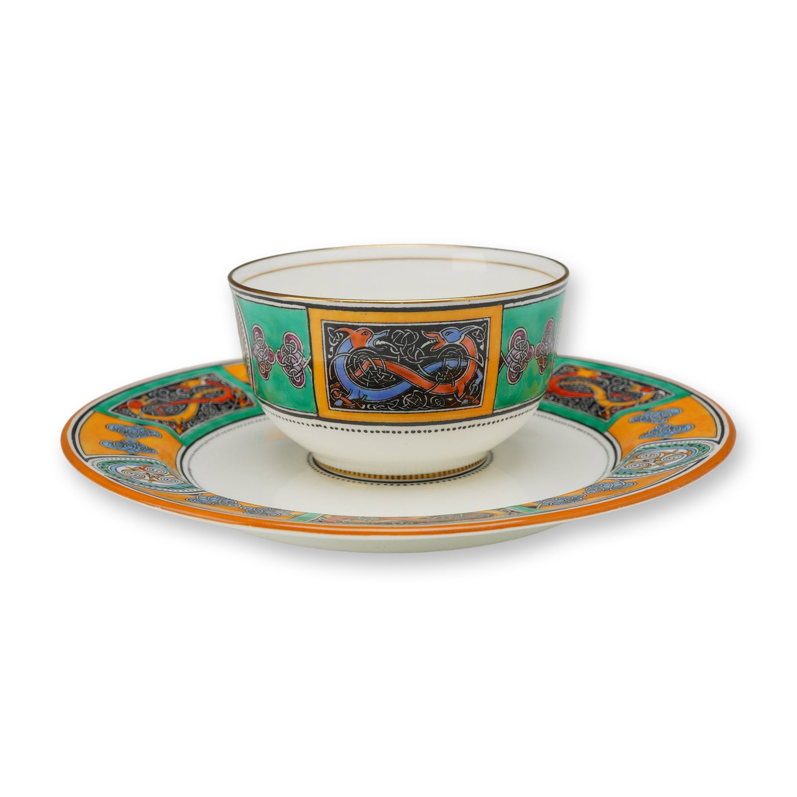 Wedgwood by Daisy Makeig-Jones Bone China Teabowl and Saucer, Celtic Pattern: The set consists of a handleless cup and a circular saucer decorated with hand-enameled motifs in shades of green, orange, blue, and mauve over black transfer-printed outlines. The decoration includes