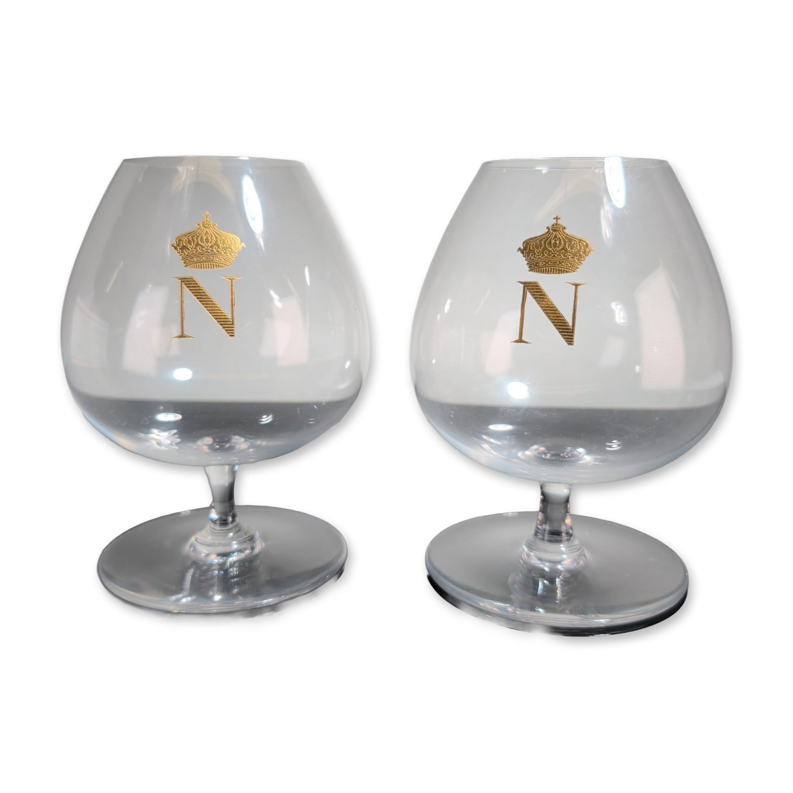 2pc Baccarat France Crystal Napoleon Brandy Snifters: Baccarat, France, pair of brandy snifters in lead crystal, featuring gold-gilt decoration. Each bowl is decorated with a Napoleonic N monogram surmounted by an imperial crown. The underside of each ba