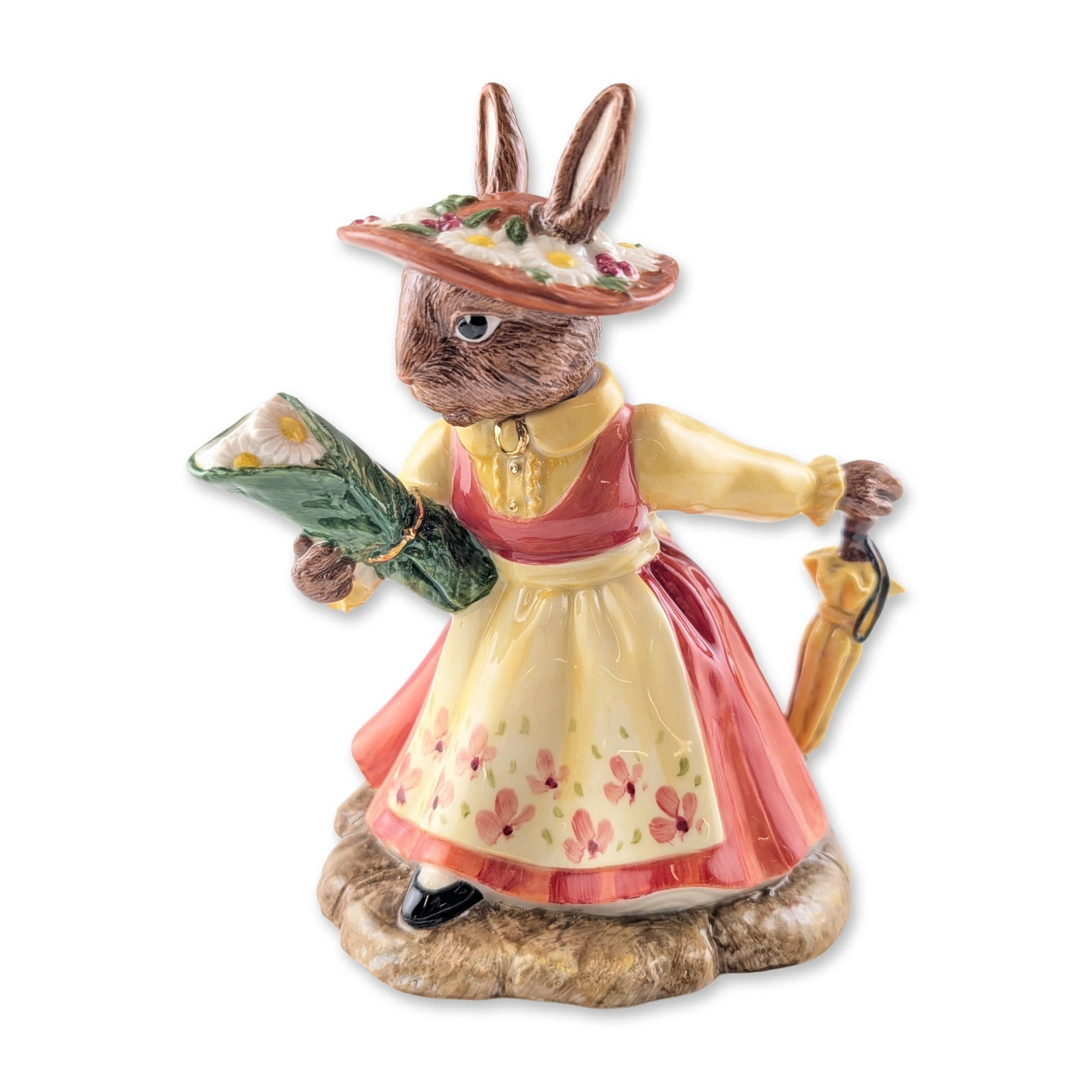 Royal Doulton Bunnykins Prototype Teapot, Lady of the Manor DBD2: The polychrome-glazed figure depicts an anthropomorphic rabbit wearing a red bodice and skirt, a yellow blouse, and a floral-patterned apron, while holding a bouquet of white flowers and a folded yell