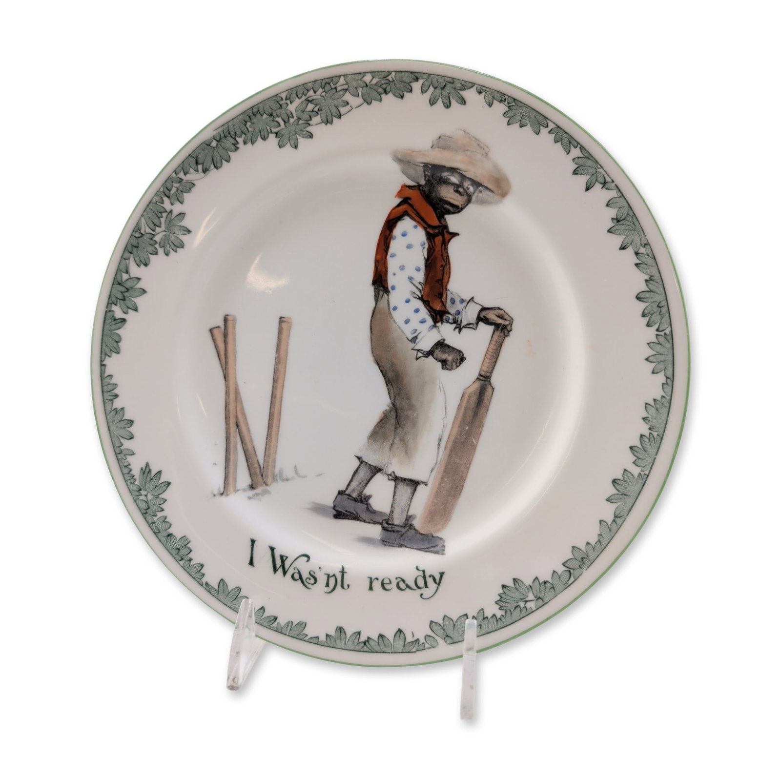 Royal Doulton Black Cricketers Series Porcelain Plate, I Wasn't Ready E4336: A plate from the Cricket series, featuring a center caricature of a cricket player standing beside fallen wickets. The illustration includes the caption I Wasn't Ready and depicts the figure in a blue