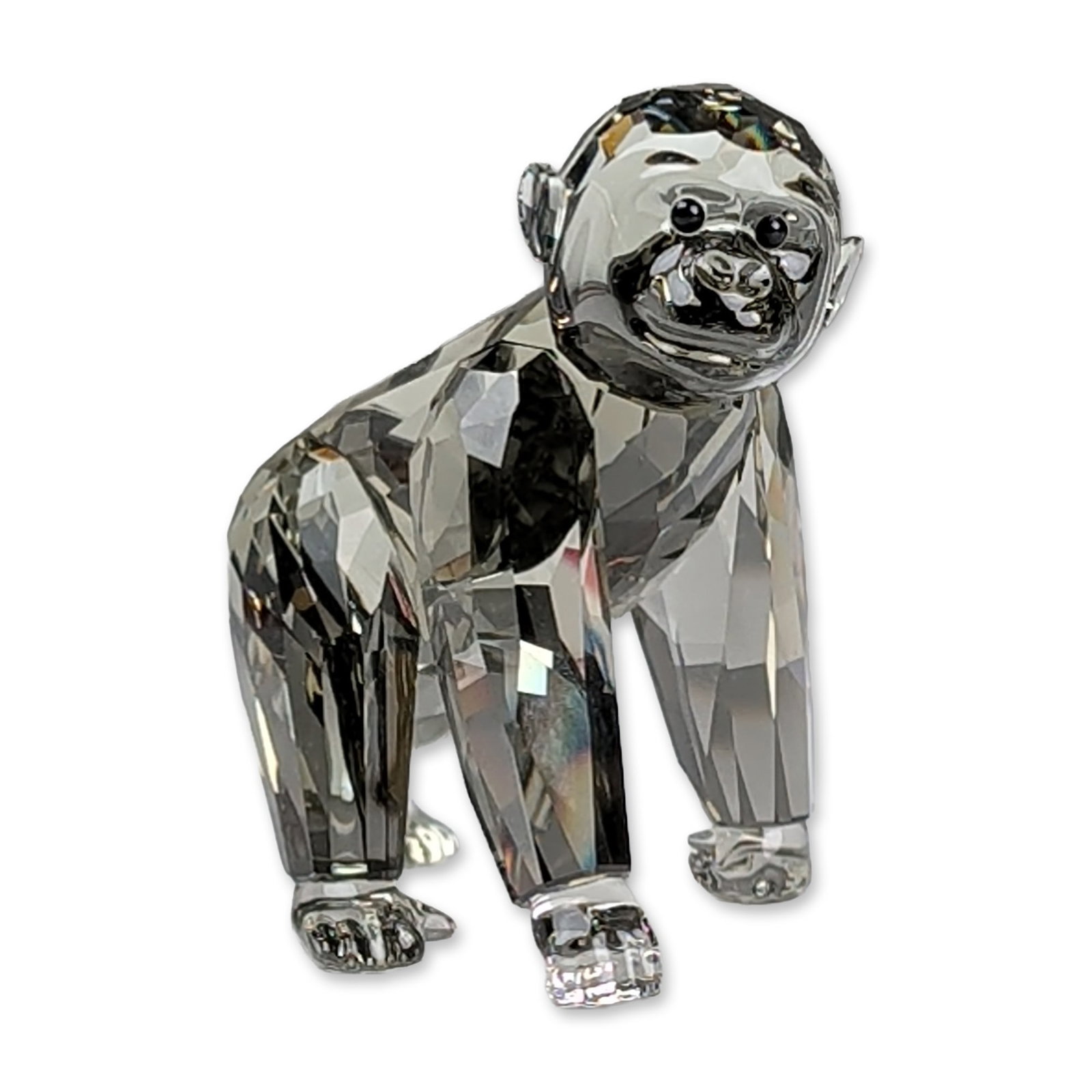 Swarovski SCS Crystal Gorilla Cub Figurine: Swarovski Crystal Society 2009 exclusive gorilla cub figurine depicted in a characteristic knuckle-walking pose. This faceted crystal piece is executed in the Silver Shadow colorway and features black