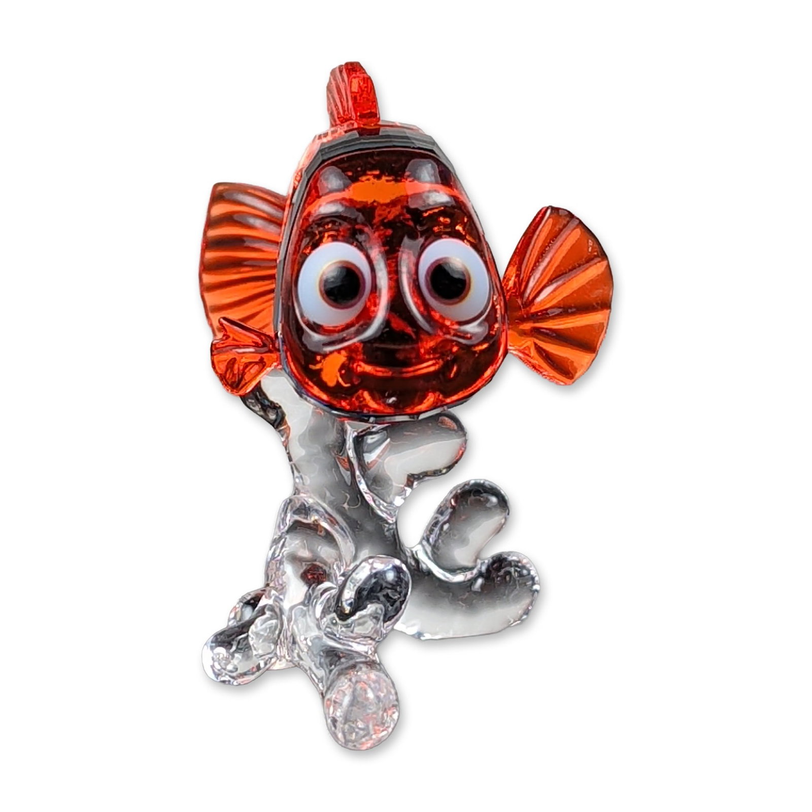 Swarovski Crystal Disney Nemo Figurine: Swarovski crystal figurine depicting the character Nemo from Disney Pixar Finding Nemo. The clownfish is rendered in faceted orange crystal with white and black crystal stripes, shown swimming through