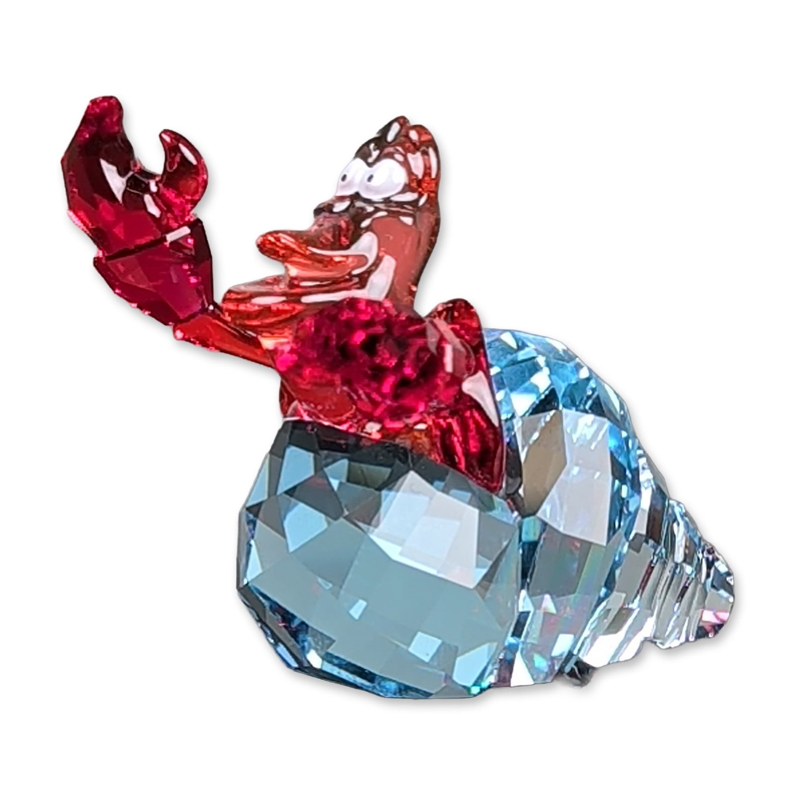 Swarovski Crystal Disney The Little Mermaid Figurine, Sebastian: Swarovski Disney collection faceted crystal figurine of Sebastian the crab from The Little Mermaid. The piece is composed of a red crystal crab alongside a two-toned blue crystal shell. The base facet