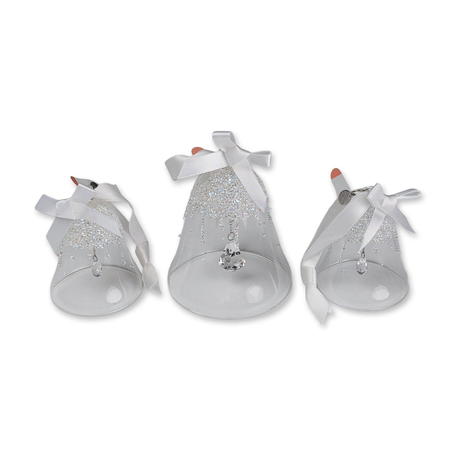 3pc Swarovski Crystal 2017 Christmas Bell Ornament Set: Trio of crystal bell ornaments featuring clear glass bodies with tops encrusted in small, faceted clear crystals. Each bell is finished with a white satin ribbon bow for hanging and a faceted crystal 