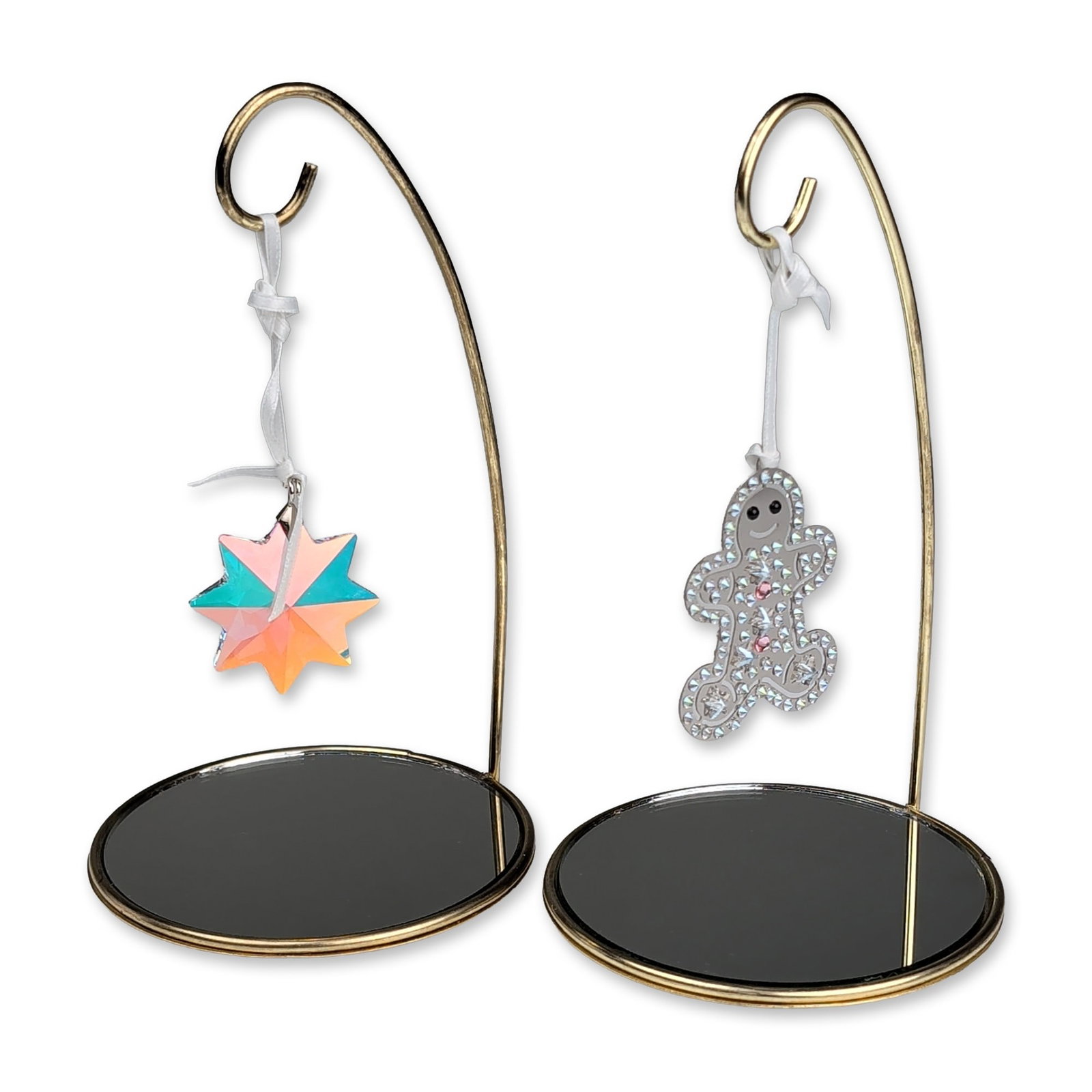 4pc Swarovski Crystal Gingerbread and Star Ornaments with Mirrored Stands: Swarovski. Two holiday ornaments in crystal and metal, featuring a gingerbread man and a star. The gingerbread man is constructed with a silver-toned metal frame pave-set with clear crystals and accen