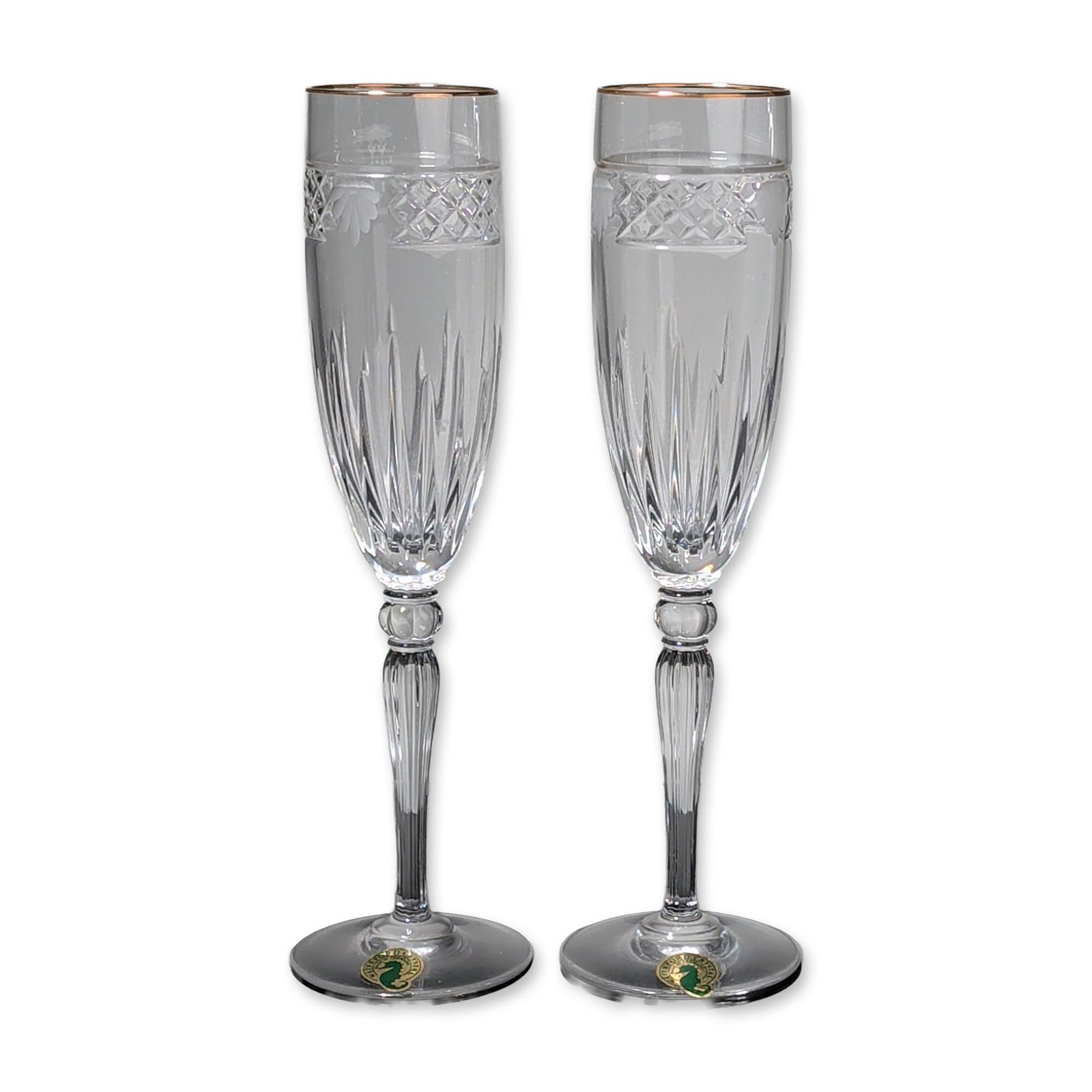 Pair of Waterford Crystal Champagne Flutes with Gilt Rim, Carleton Shell: Each flute is crafted from clear lead crystal featuring a tapered bowl with a gilded rim and a hand-cut design. The decorative program includes a band of diamond cutting above deep vertical wedge cuts