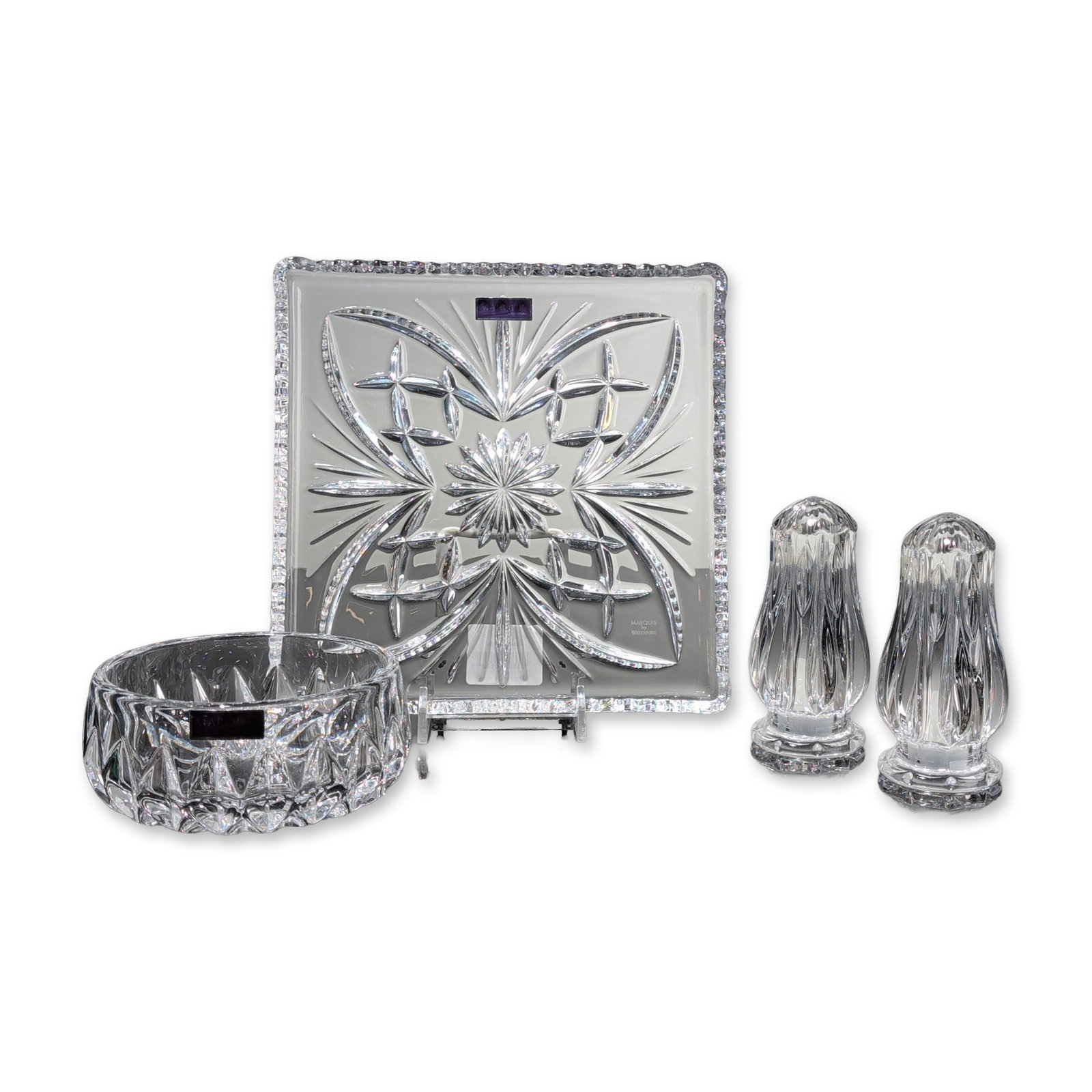 Group of Four Marquis by Waterford Crystal Items- Tray, Bowl and Shakers: Marquis by Waterford. Group of four lead crystal tableware pieces, including a Newberry pattern square tray with starburst and leaf-like geometric cuts, a round bowl with repeating diamond wedge cuts,