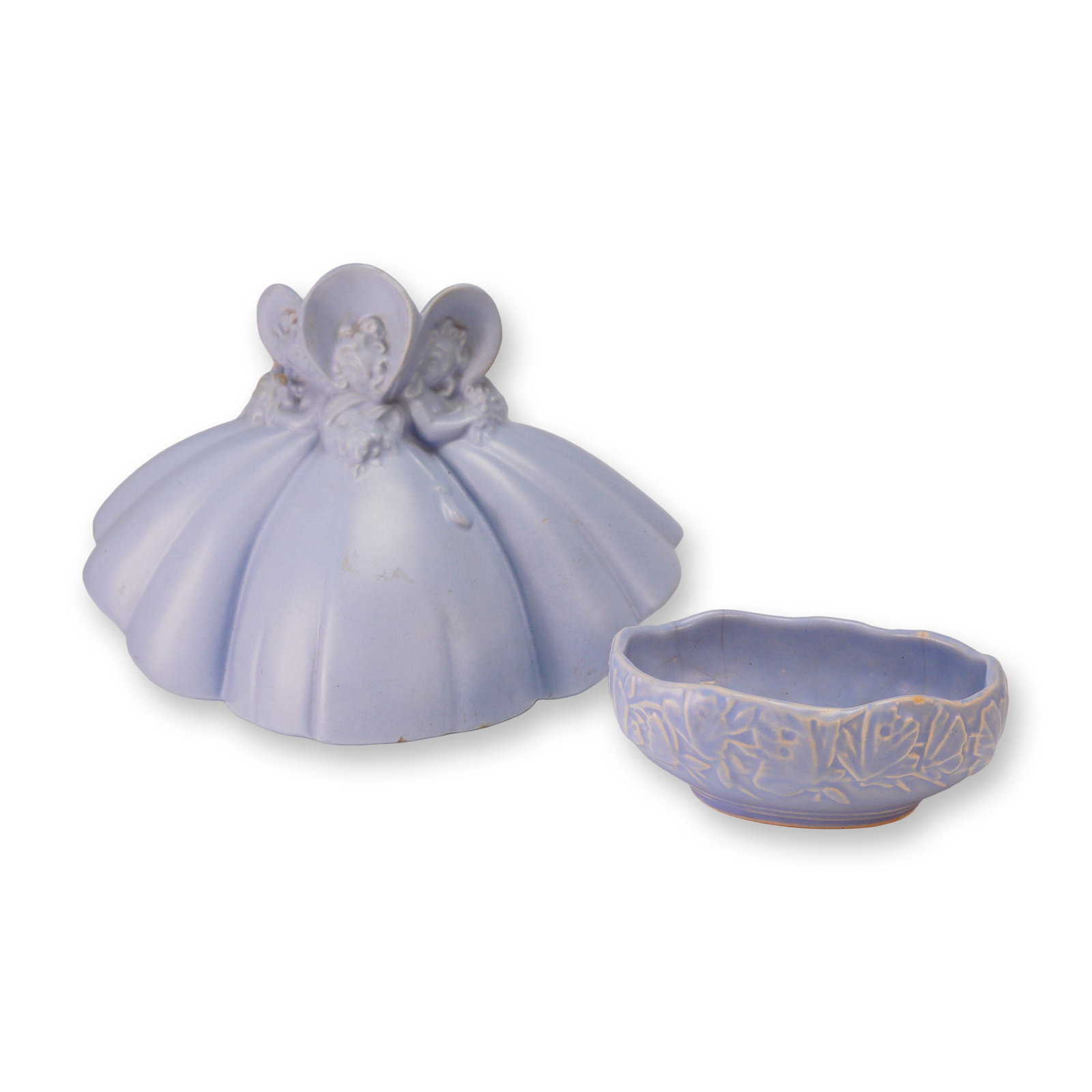Haeger and McCoy, Southern Belle and Leaf Planters: This lot features two pieces of American art pottery finished in a uniform matte periwinkle blue satin glaze. The first piece is a Royal Haeger figural planter depicting three Victorian-style Southern
