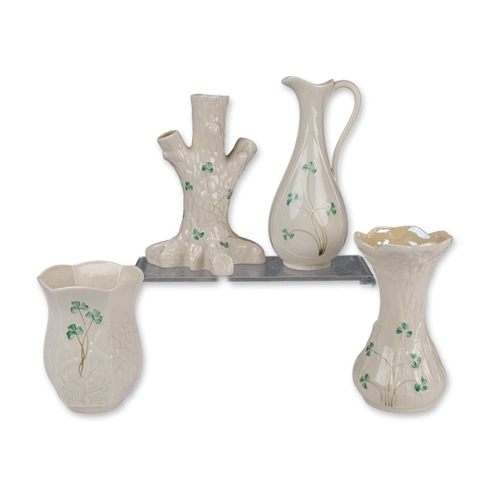 Collection of Four Belleek Ireland Shamrock Parian Porcelain Vases and Ewer: Belleek Pottery, Ireland. Collection of parian porcelain items in the Shamrock pattern, featuring hand-painted green shamrock sprigs on embossed cream-colored grounds. The assortment includes a slende