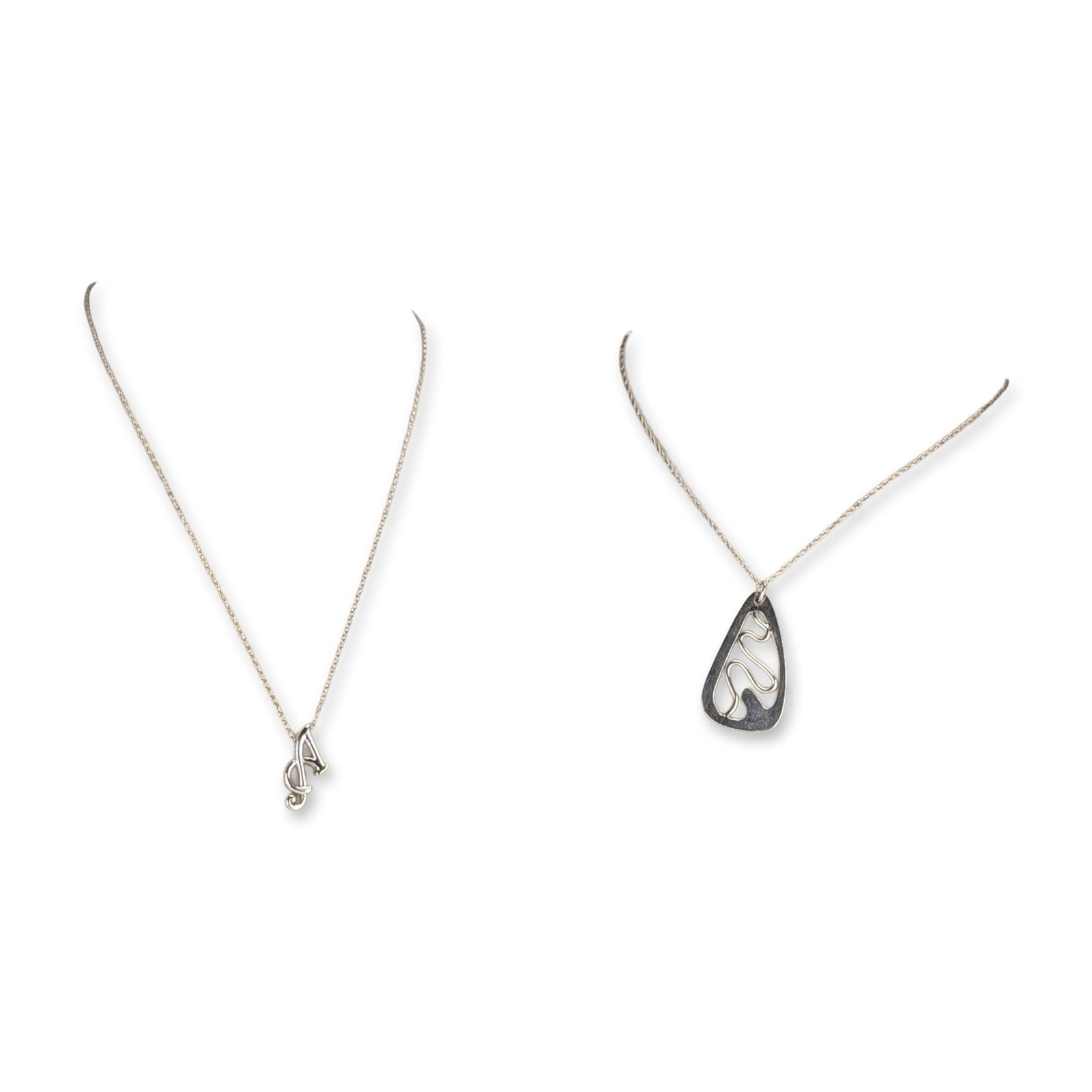 2pc Sterling Silver Pendant Necklaces: Two sterling silver pendant necklaces. The first comprises a modernist openwork teardrop-shaped pendant with a wide polished frame and a central undulating wire motif, suspended from a fine twisted ro