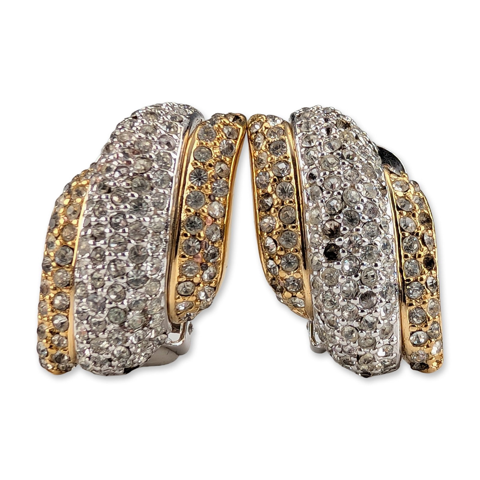 Pair of Christian Dior Two-Tone Clip Earrings: Christian Dior. Pair of vintage clip-on earrings in two-tone gold and silver-tone base metal, featuring a three-dimensional tiered swirl design pave-set with clear round faceted crystals. Marked Chr.D