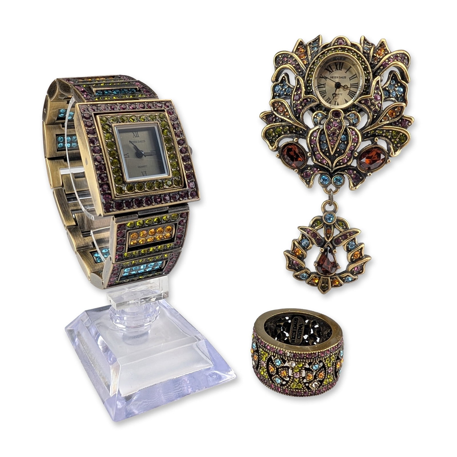 3pc Heidi Daus Art Deco Multi-Crystal Jewelry: Art Deco style jewelry trio in antiqued bronze-tone base metal, featuring a wide hinged cuff watch, a brooch watch with pendant drop, and a wide band ring. Pieces are decorated with openwork filigree 