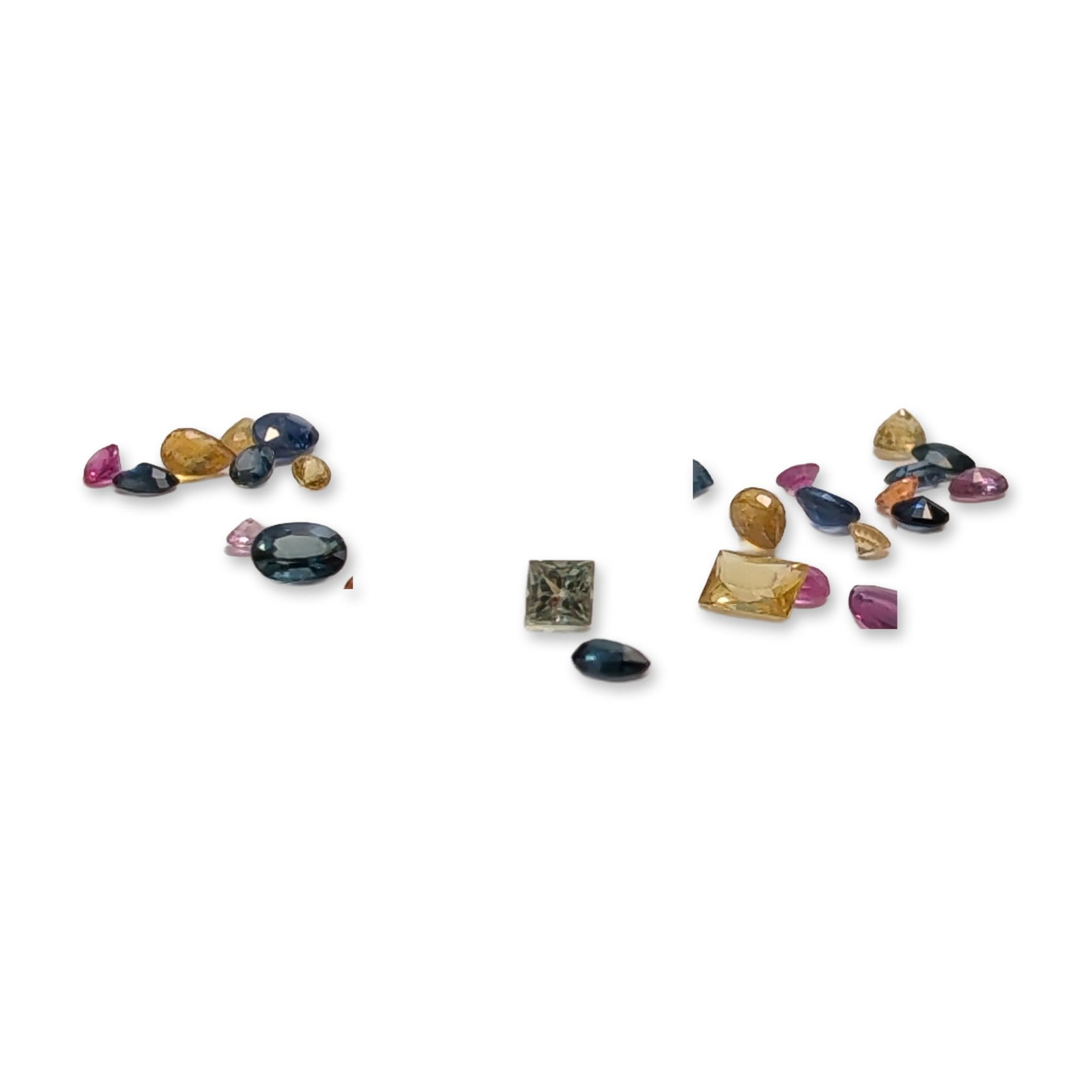 Assortment of Multi-Colored Loose Fancy Sapphires: Assortment of loose gemstones, appears to be fancy colored sapphires in a diverse palette including navy blue, medium blue, golden yellow, pale yellow, pink, rose pink, lavender, burnt orange, and pal
