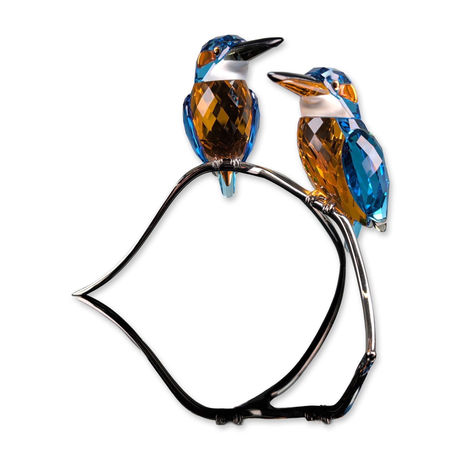 Swarovski Crystal Paradise Collection Kingfishers Figurine: Swarovski crystal figurine from the Paradise collection featuring a pair of kingfishers perched on a stylized rhodium-plated metal branch. The birds are constructed from faceted crystal in shades of b