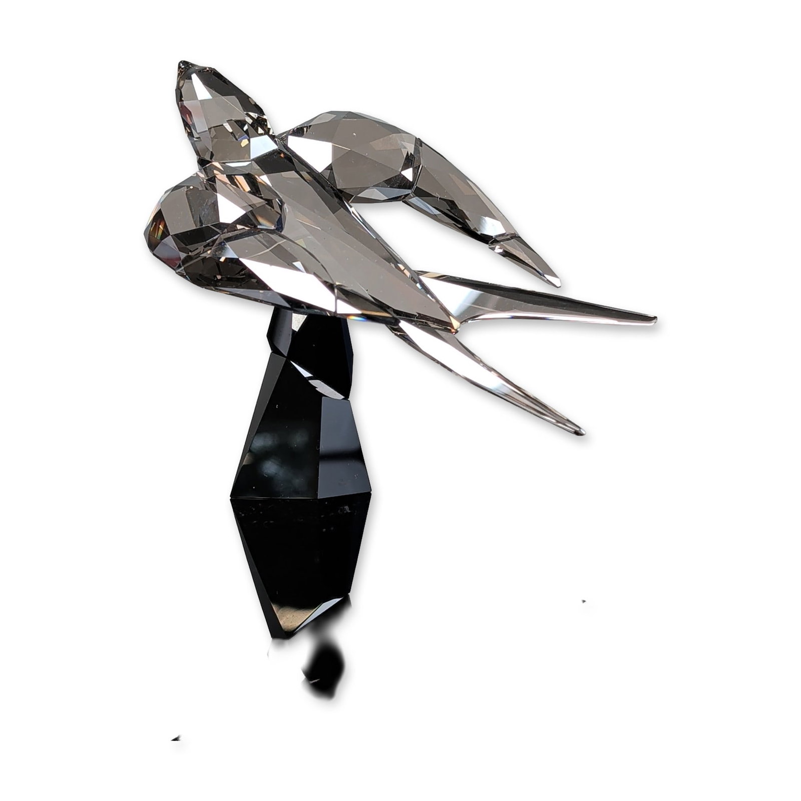 Swarovski Crystal Soulmates Figuring, Swallow: Swarovski Soulmates collection swallow figurine in graphite colored faceted lead crystal. The bird is depicted in a flight pose with spread wings and a deeply forked tail, mounted on a faceted black c