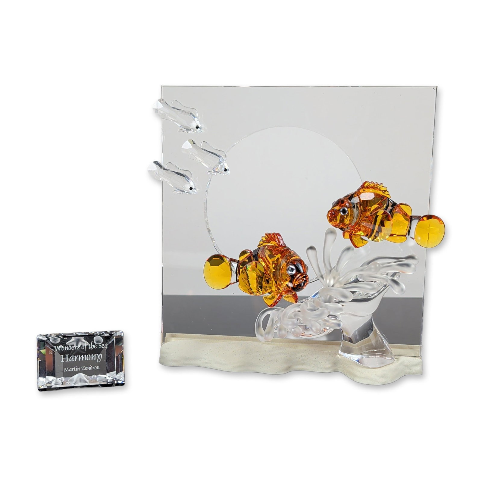 2pc Swarovski Wonders of the Sea Harmony Crystal Figurine with Title Plaque: Swarovski Wonders of the Sea series Harmony crystal sculpture designed by Martin Zendron. The lead crystal piece depicts two clownfish in faceted orange and amber crystal with black eyes, positioned w