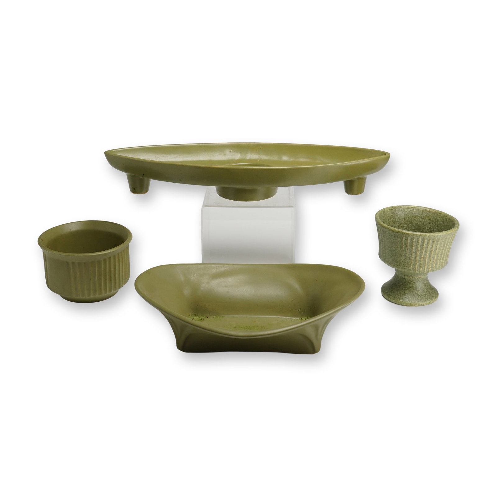 A Collection of Floraline and McCoy Green Pottery Bowls and Candleholders: A collection of mid-century modern ceramic floral vessels and containers from the Floraline line by McCoy, finished in a uniform matte olive green glaze. The group includes an elongated almond-shaped 