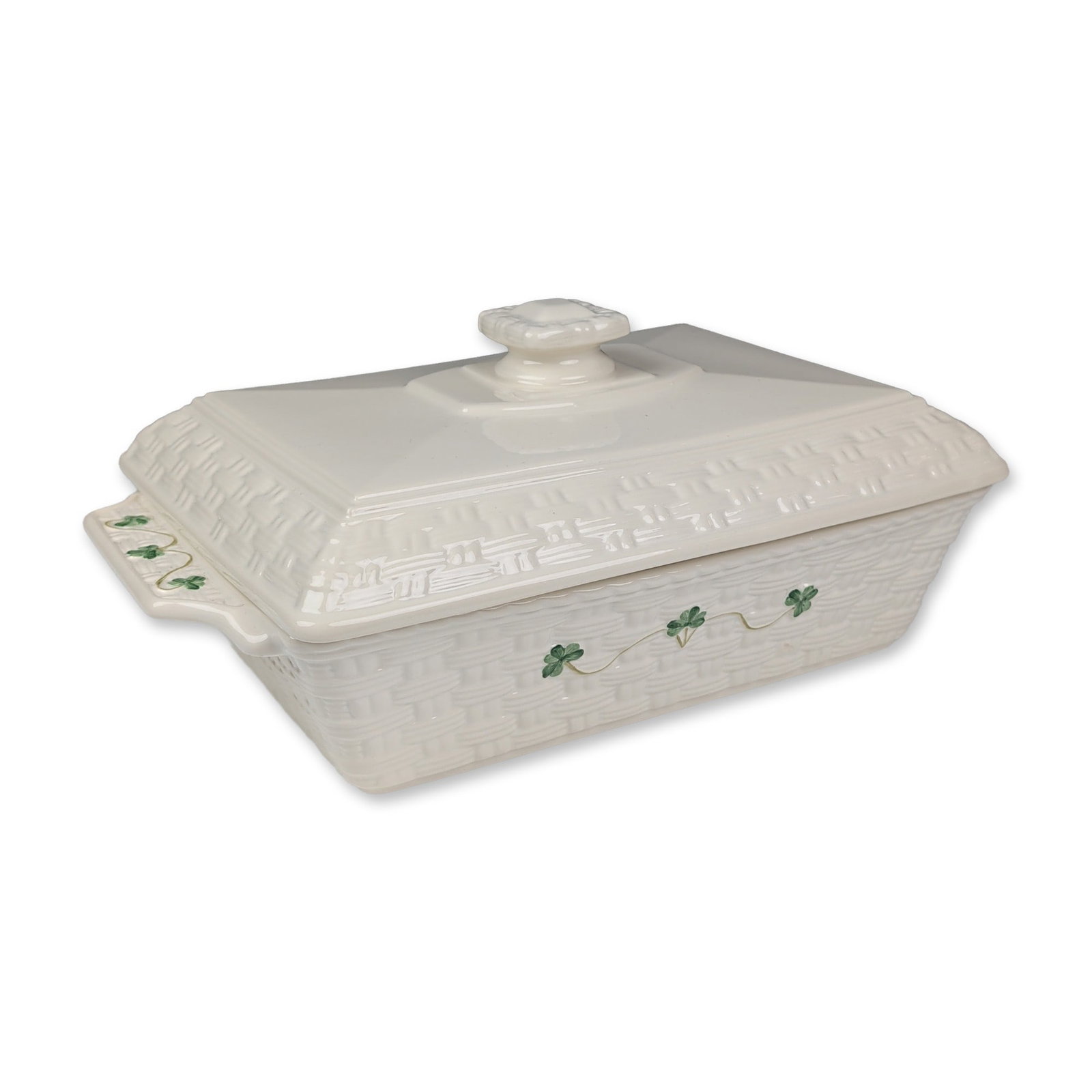 Belleek Ireland Everyday Shamrock Covered Casserole: Belleek Everyday pattern rectangular covered casserole dish in glazed cream ceramic. The body and lid feature a relief-molded basketweave texture with hand-painted green shamrocks and brown vine detai
