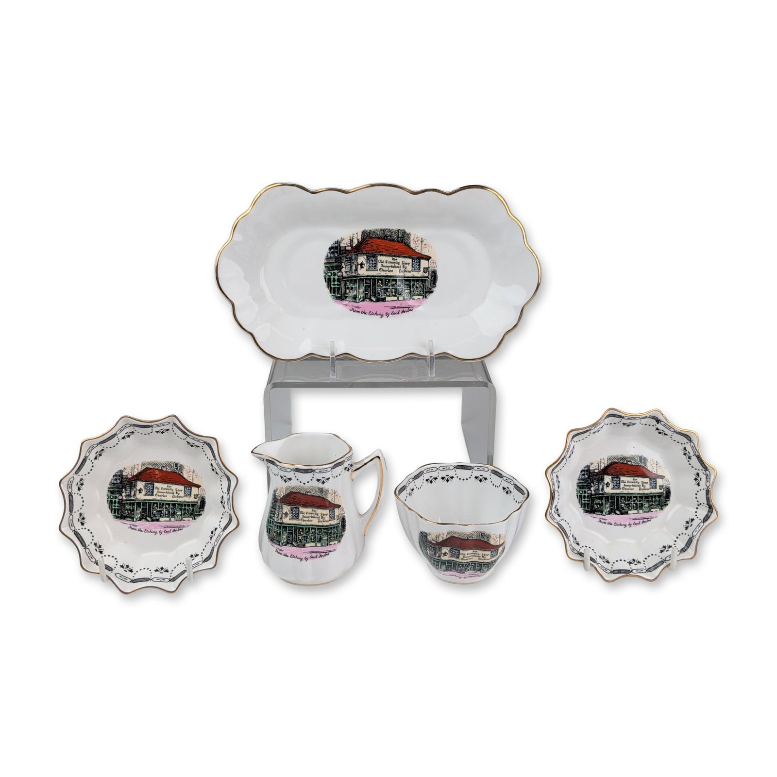 5pc Rosina Bone China Dickens Old Curiosity Shop Dishes & Creamer Set: Five-piece set featuring polychrome transfer-printed scenes of The Old Curiosity Shop after an etching by Cecil Forbes. Each piece includes the text The Old Curiosity Shop immortalized By Charles Dick