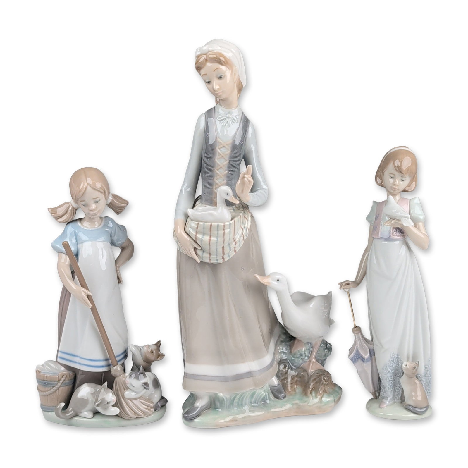3pc Lladro Porcelain Figurines- Summer Stroll 7611, Playful Kittens 5232 & Girl with Goose 4815: Lladro Spanish glazed porcelain collection comprising three figurines executed in the factory signature muted pastel palette of soft blues, grays, and beiges. The group includes girl in a white dress 