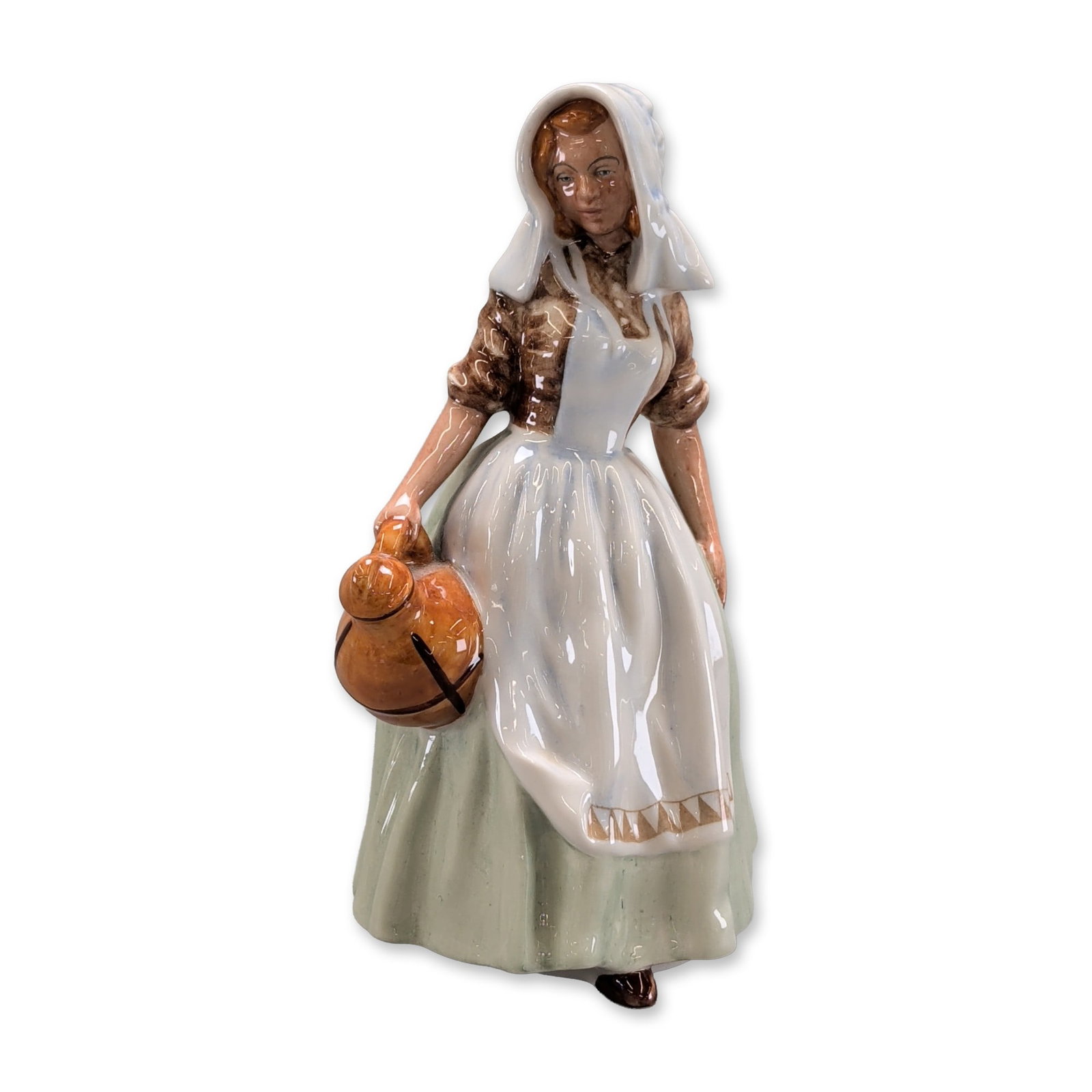 Royal Doulton The Milkmaid Porcelain Figurine HN 2057: An English Royal Doulton glazed bone china figurine titled The Milkmaid, model HN 2057. The figure is depicted in a walking pose, wearing a brown bodice with puffed sleeves, a white apron featuring a 