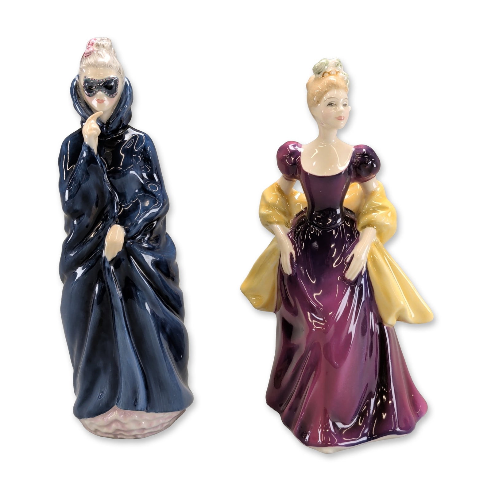 2pc Royal Doulton Porcelain Figurines, Masquerade and Loretta: Royal Doulton hand-painted glazed bone china figurines, England. The pair includes the "Loretta" model, a female figure in a purple off-the-shoulder gown with a yellow shawl, and the "Masquerade" mode