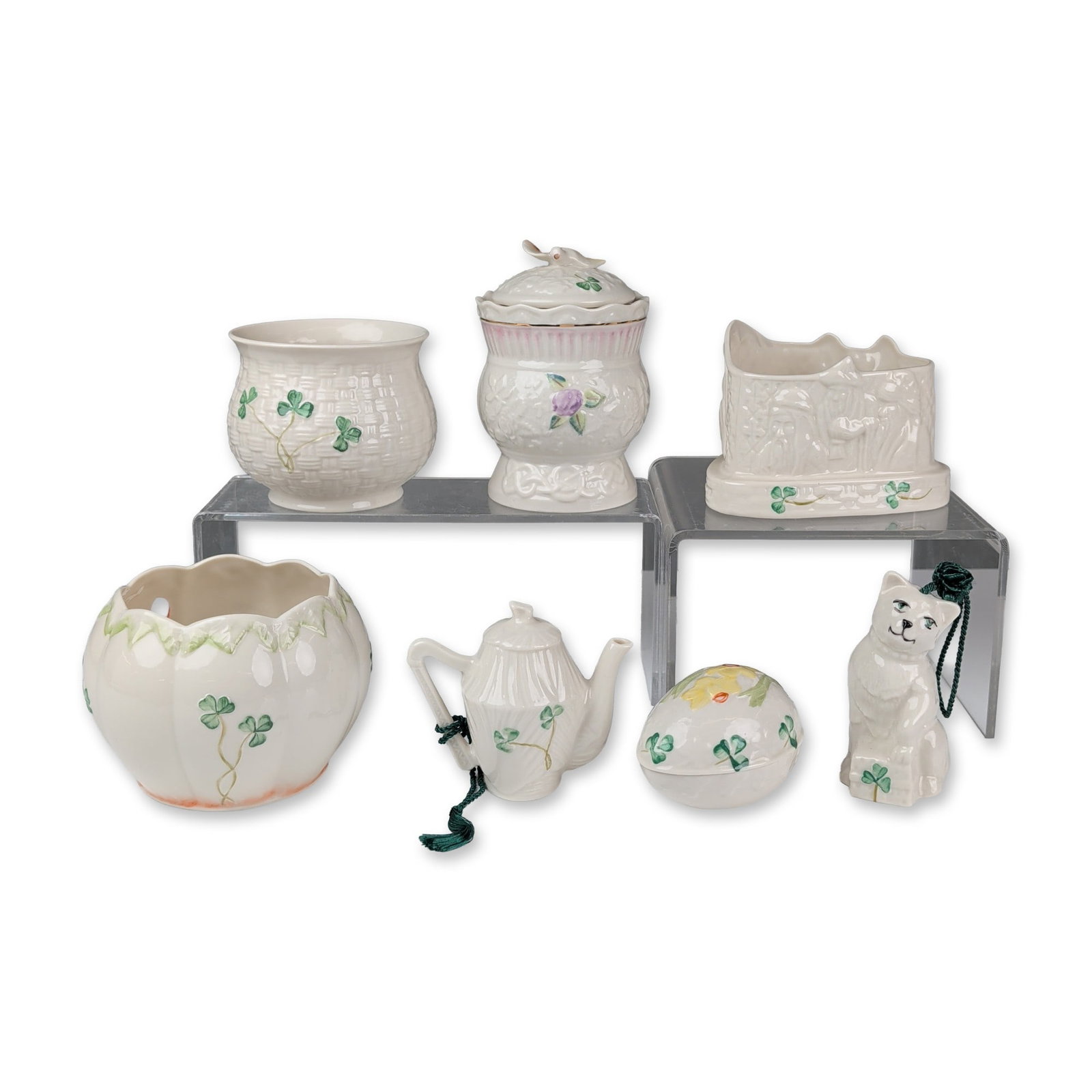 Collection of Seven Belleek Ireland Parian Porcelain Bowl, Ornaments & Lidded Pot: Belleek Parian porcelain group, Ireland. Collection featuring molded relief basketweave and hand-painted shamrock motifs. Includes a lidded honey pot with bird finial, a lobed pumpkin bowl with orange