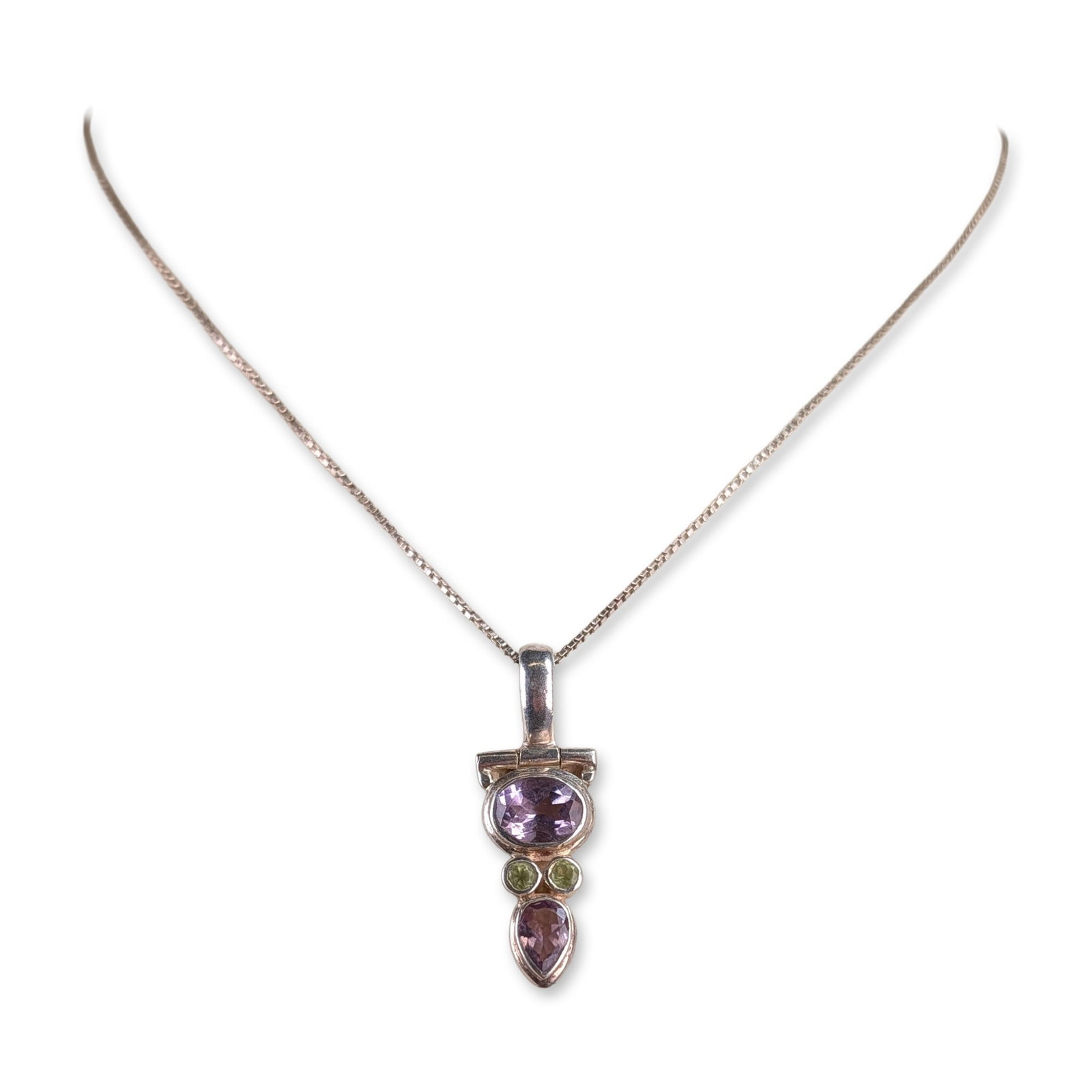 Sterling Silver Amethyst and Peridot Pendant Necklace: Sterling silver articulated pendant necklace featuring four bezel-set gemstones in a vertical arrangement. The setting includes one oval-cut amethyst, two round-cut peridots, and one pear-cut amethyst