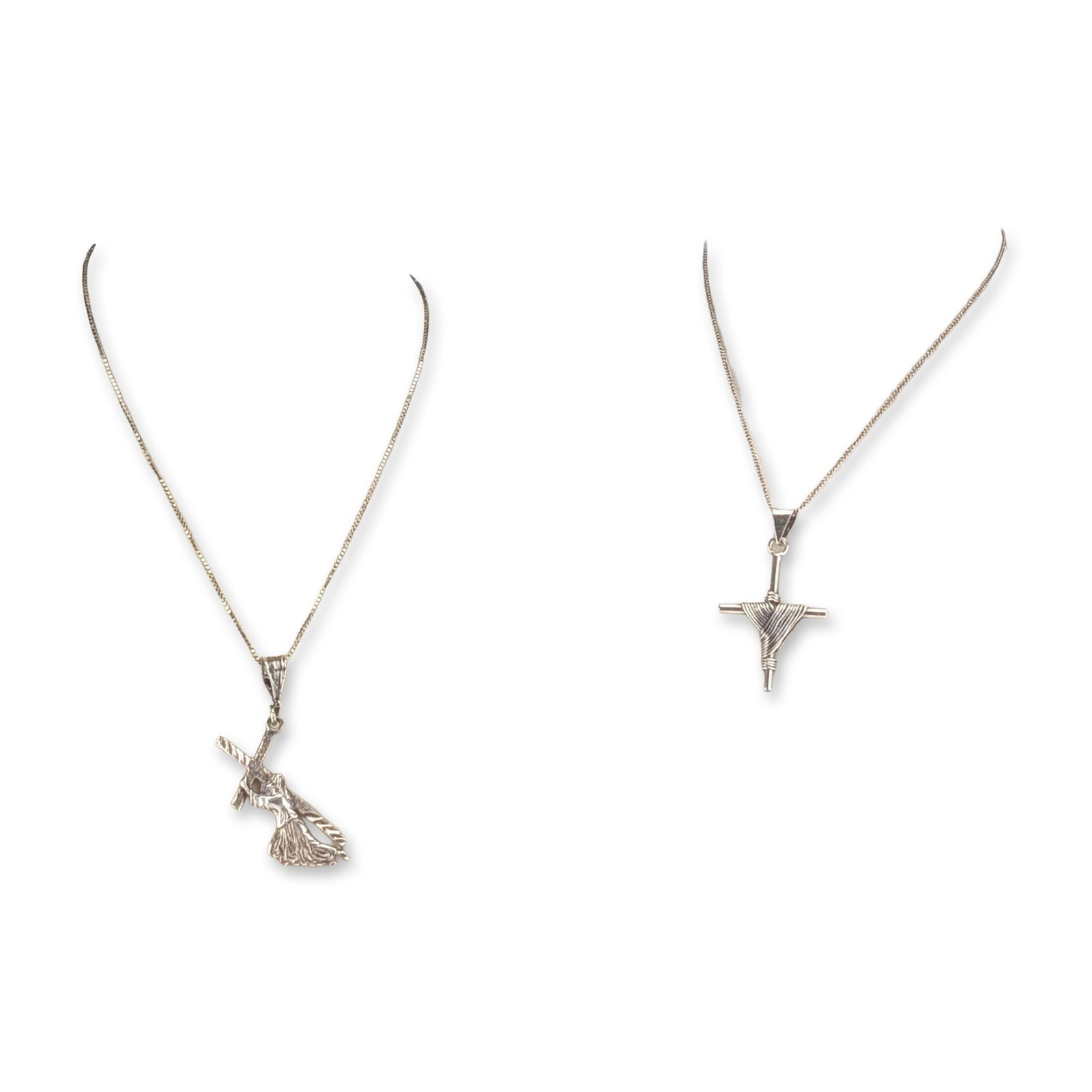 2pc Sterling Silver Religious Pendant Necklaces: Two sterling silver pendant necklaces featuring religious iconography. The first necklace includes a cast sterling silver pendant depicting Jesus carrying a textured cross. The pendant features a pebb
