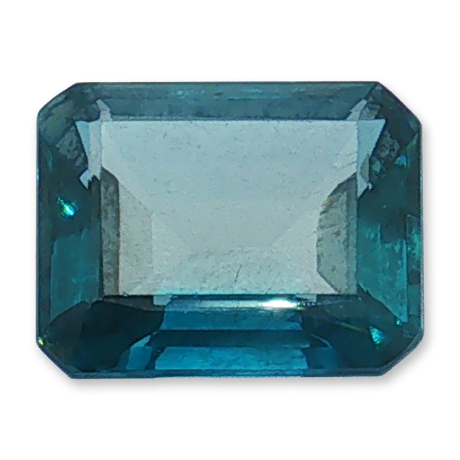 Loose Emerald Cut Blue Topaz Gemstone: Faceted loose gemstone, appearing to be blue topaz in a saturated London Blue variety. The stone features a rectangular emerald cut with truncated corners and a multi-stepped pavilion. It displays a d