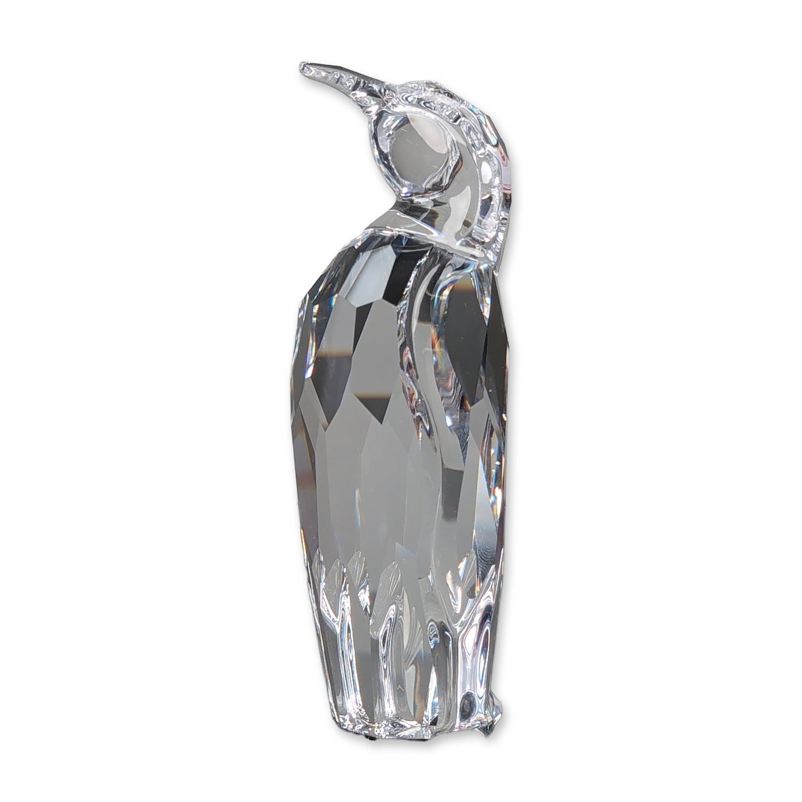 Swarovski Crystal Figurine, Penguin Father: Penguin Father is crafted from faceted lead crystal. The figure features a pear-shaped body with light-refracting facets, a smooth head, and a long, downward-tapering beak. A laser-etched Swarovski sw