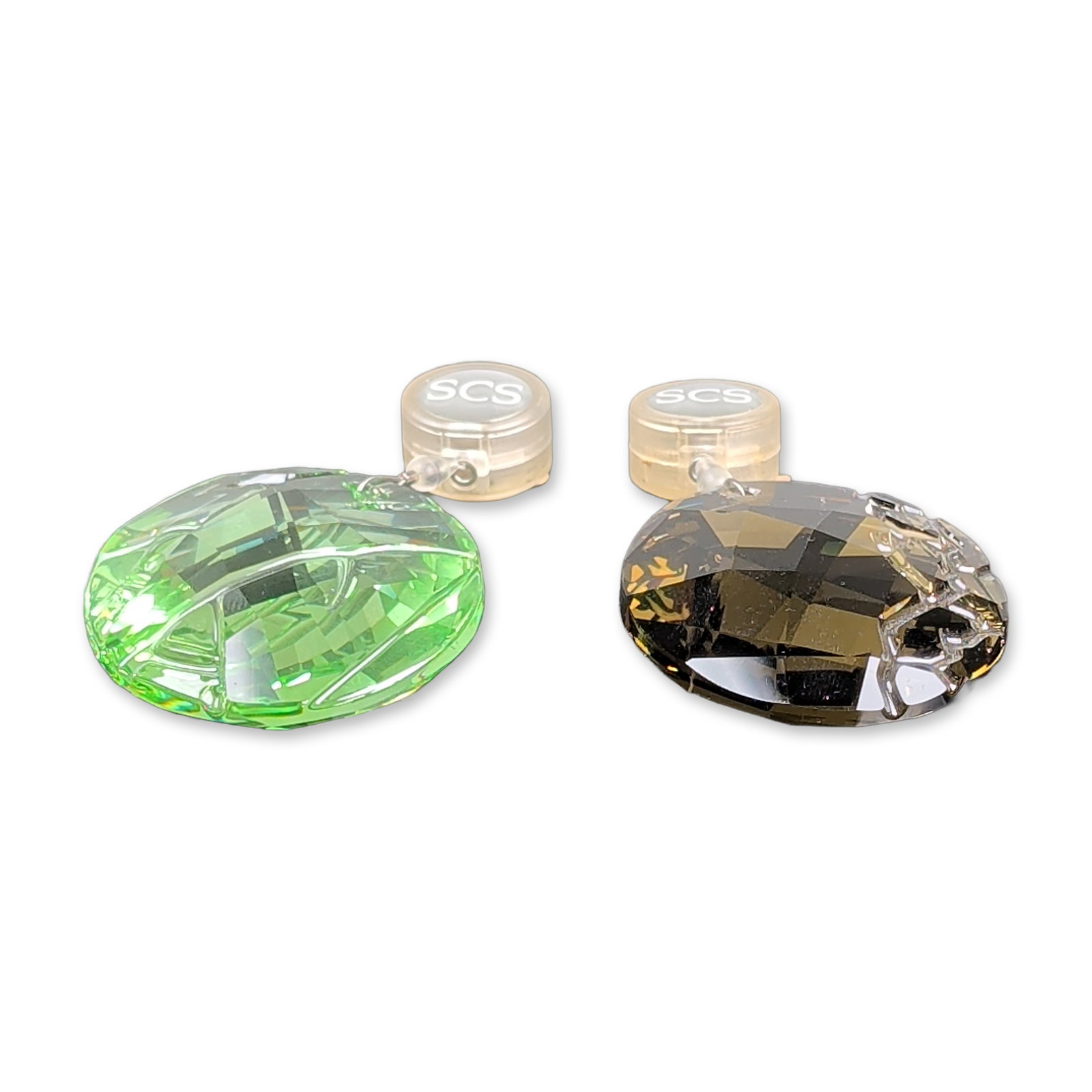 Two Swarovski SCS Crystal Window Suncatchers: Faceted crystal window ornaments or suncatchers. The set includes one peridot green crystal in the Bamboo pattern and one smoky-gray crystal featuring a silver-tone metal cage element at the top. Each