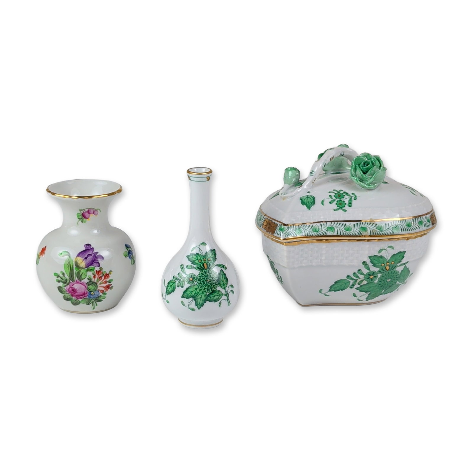 3pc Herend Hungary Porcelain Lidded Box and Miniature Vases: Herend, Hungary, trio of hand-painted porcelain floral cabinet items. The assortment features a Chinese Bouquet green heart-shaped lidded box with branch-form handles, and an applied green rose finial