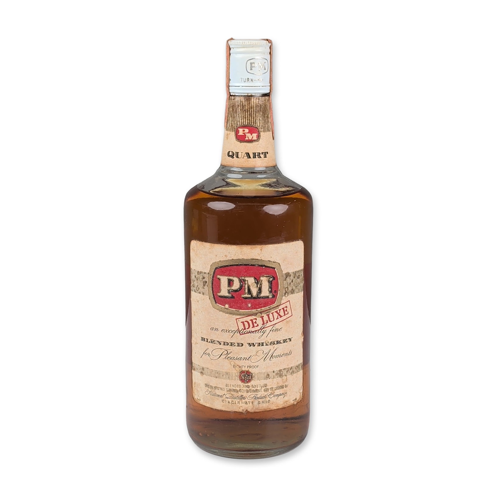 National Distillers PM De Luxe Blended Whiskey Quart: American blended whiskey produced by National Distillers Products Corp., Cincinnati, Ohio. This clear glass bottle contains PM De Luxe blended whiskey, an 80-proof spirit comprised of 30 percent strai