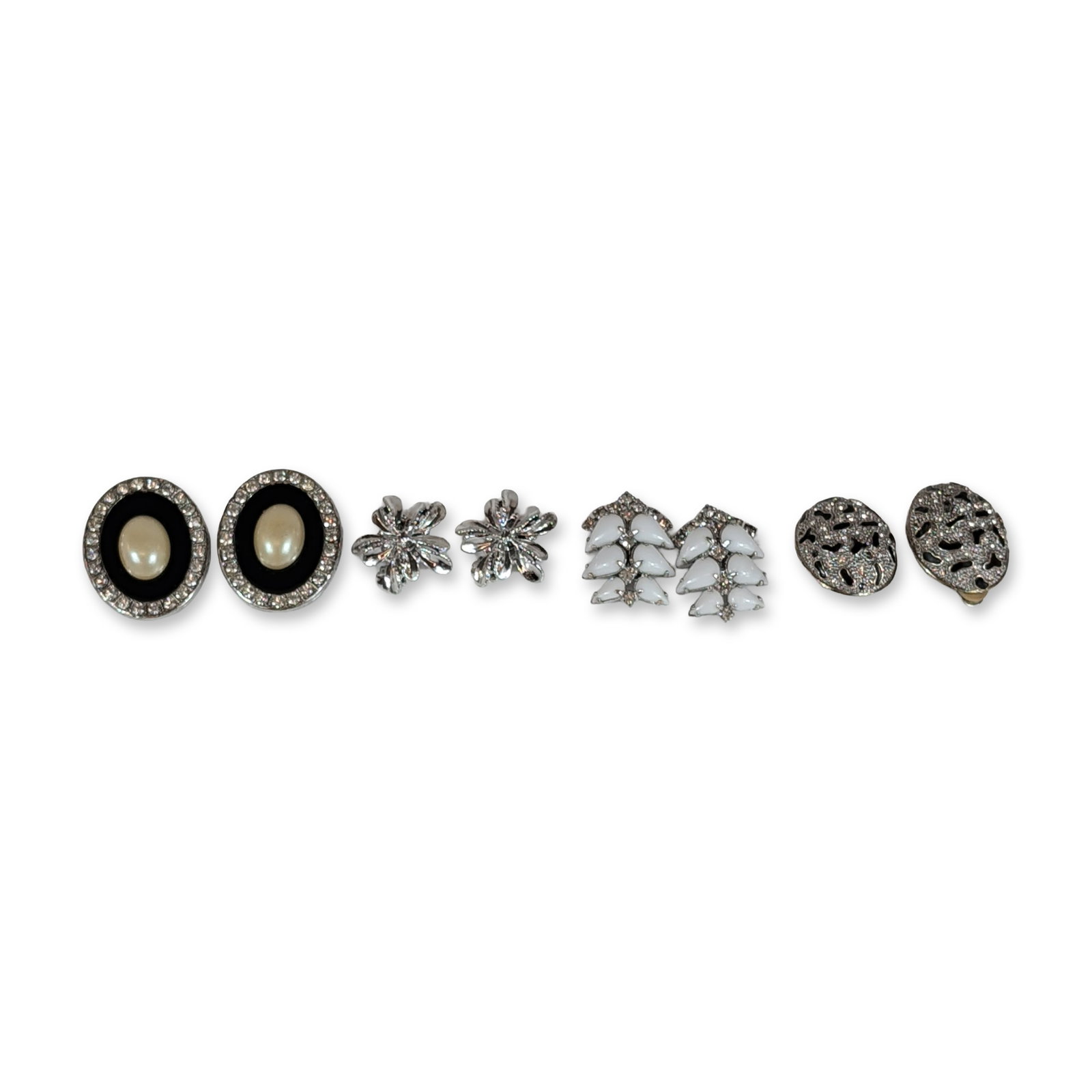 Group of Four Pairs Vintage Costume Earrings: Collection of vintage silver-tone costume clip-on earrings. Features one pair of Kramer leaf-motif earrings set with white navette-shaped opaque cabochons; one pair of oval-form earrings with clear rh