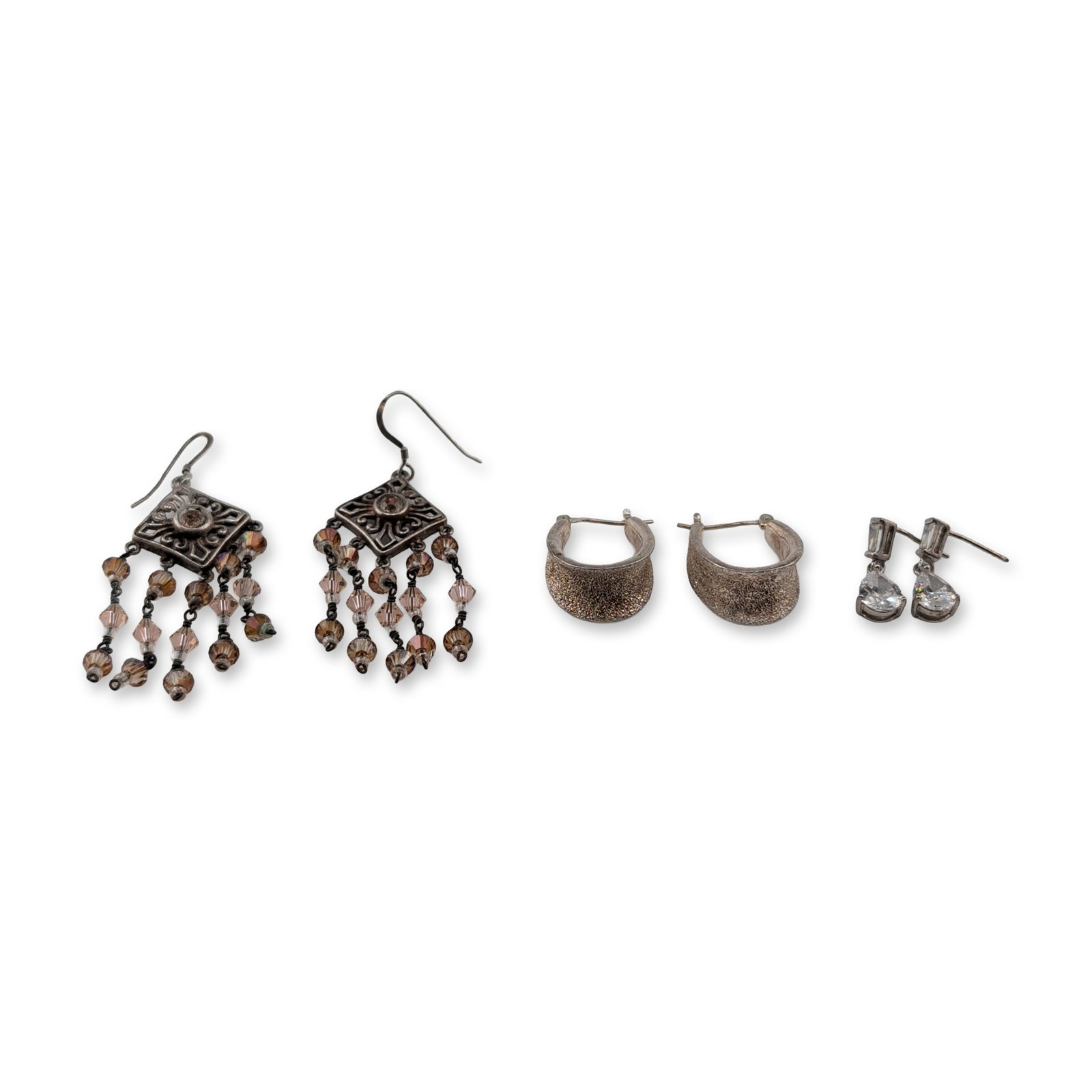 Three Pairs Sterling Silver and Beaded Earrings: Trio of matched earring pairs including sterling silver and beaded examples. The first pair consists of sterling silver drop earrings set with baguette and pear-cut clear stones, likely cubic zirconia