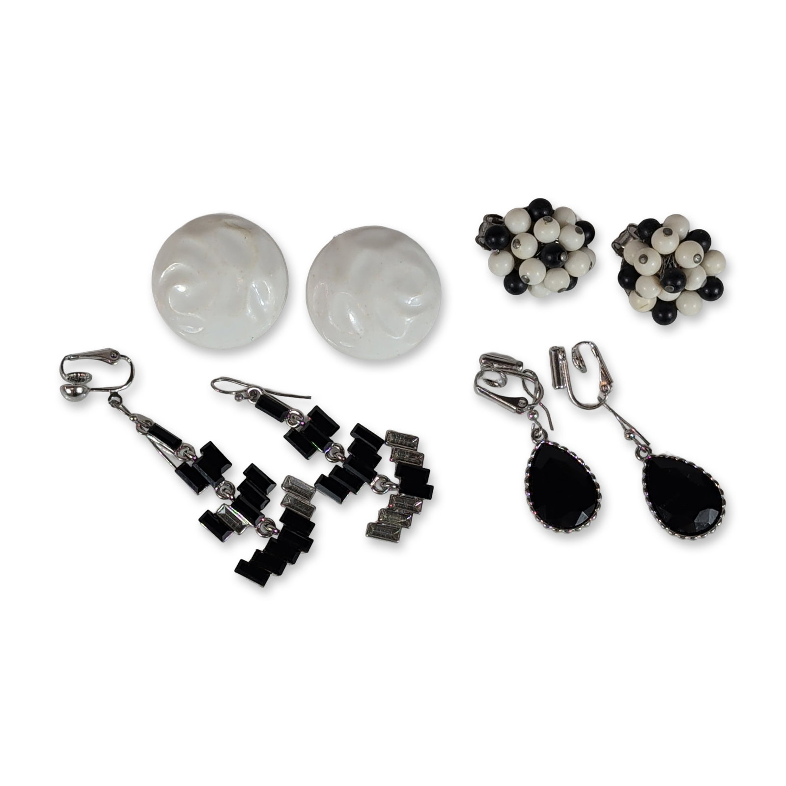 4 pair Collection of Vintage Black and White Earrings: Collection of vintage costume earrings in varied black and white designs. The group includes a pair of cluster earrings featuring small black and white round beads in silver-tone metal settings,