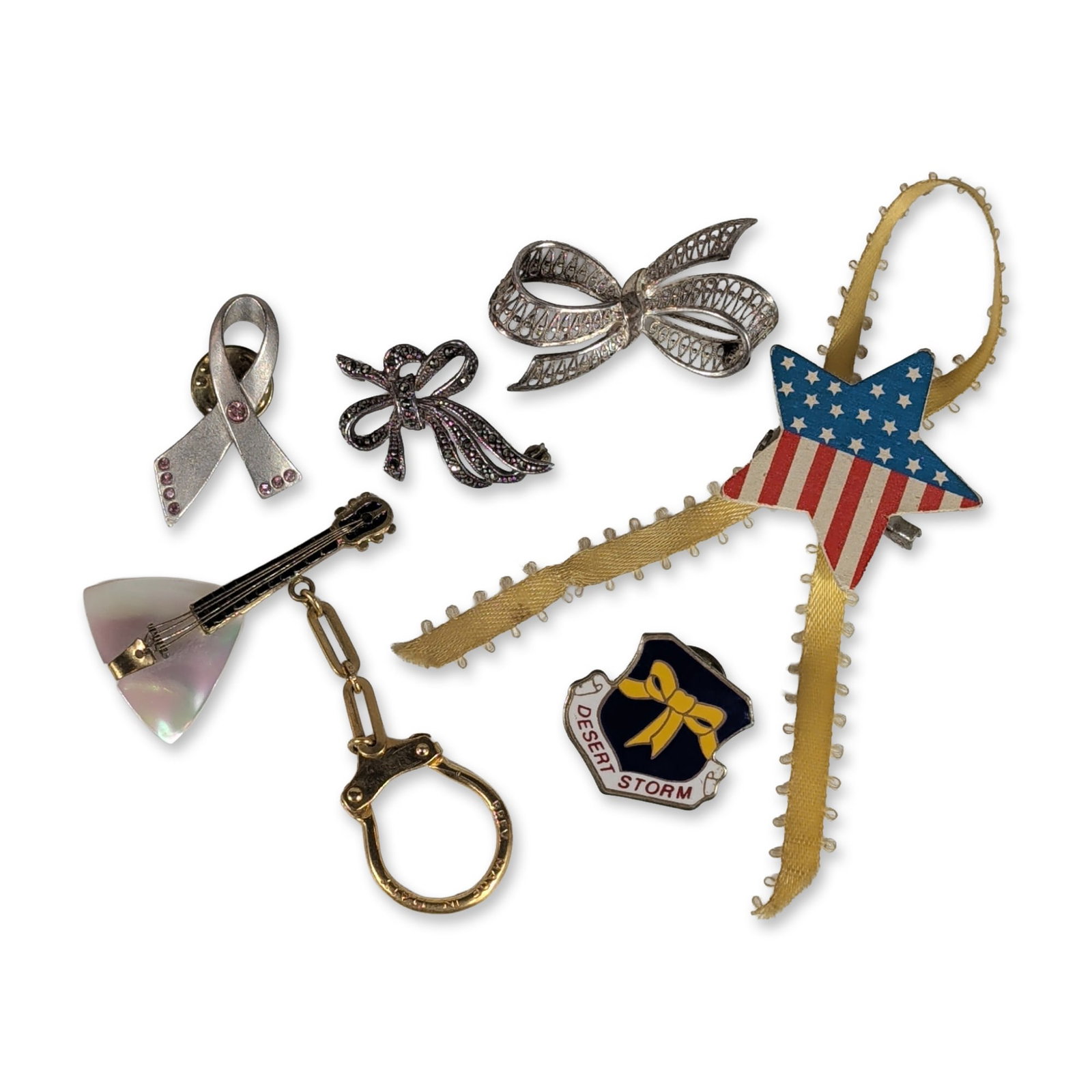 6pc Jewelry and Accessory Items: Assortment of six jewelry and accessory items featuring patriotic and awareness motifs. The collection includes a silver-tone looped awareness ribbon pin marked for Avon, accented with seven pink rhin