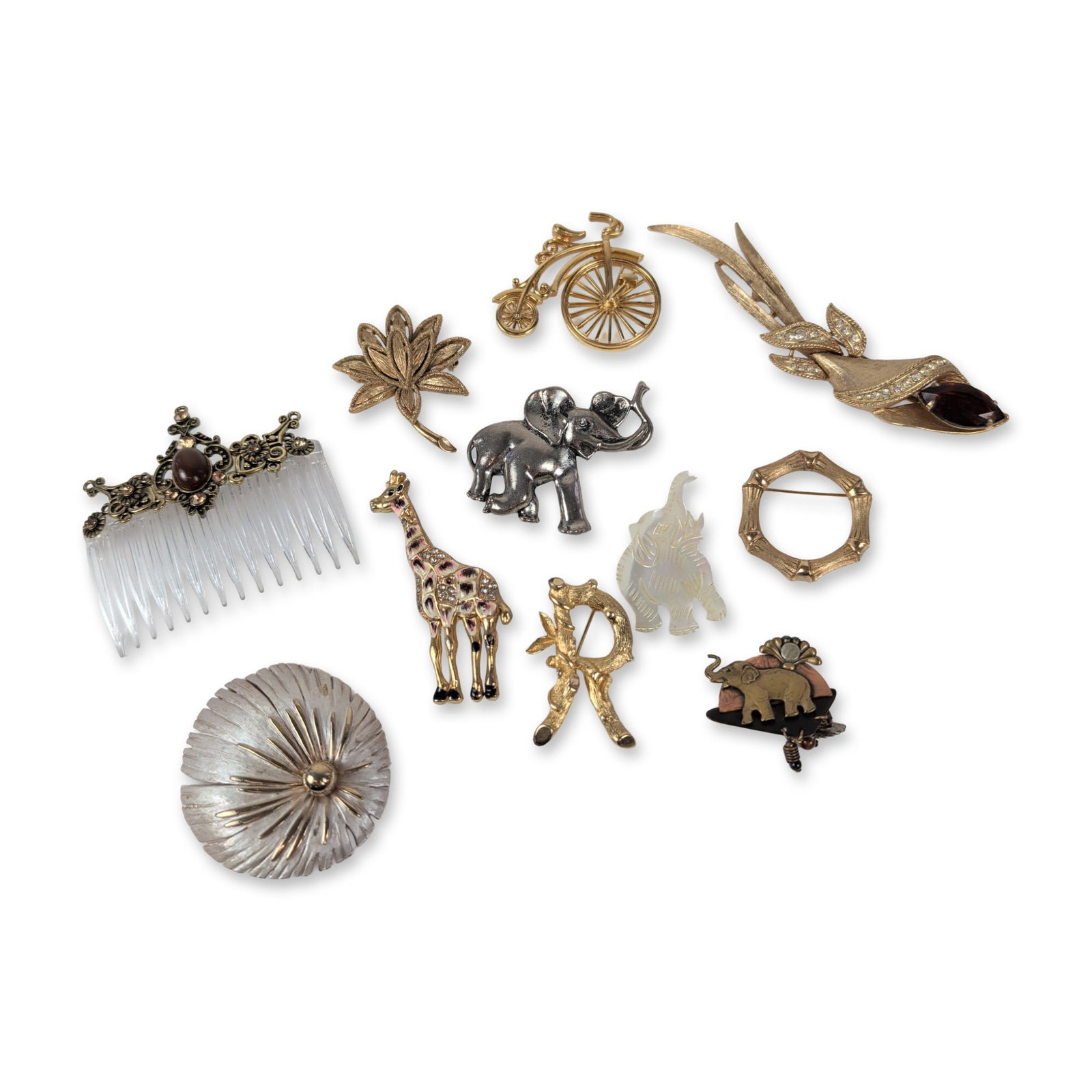 An Assortment of Eleven Vintage Costume Jewelry Pieces: An assortment of eleven vintage costume jewelry pieces, featuring ten brooches and one decorative hair comb. The collection includes a variety of motifs and materials, notably a large gold-tone calla 