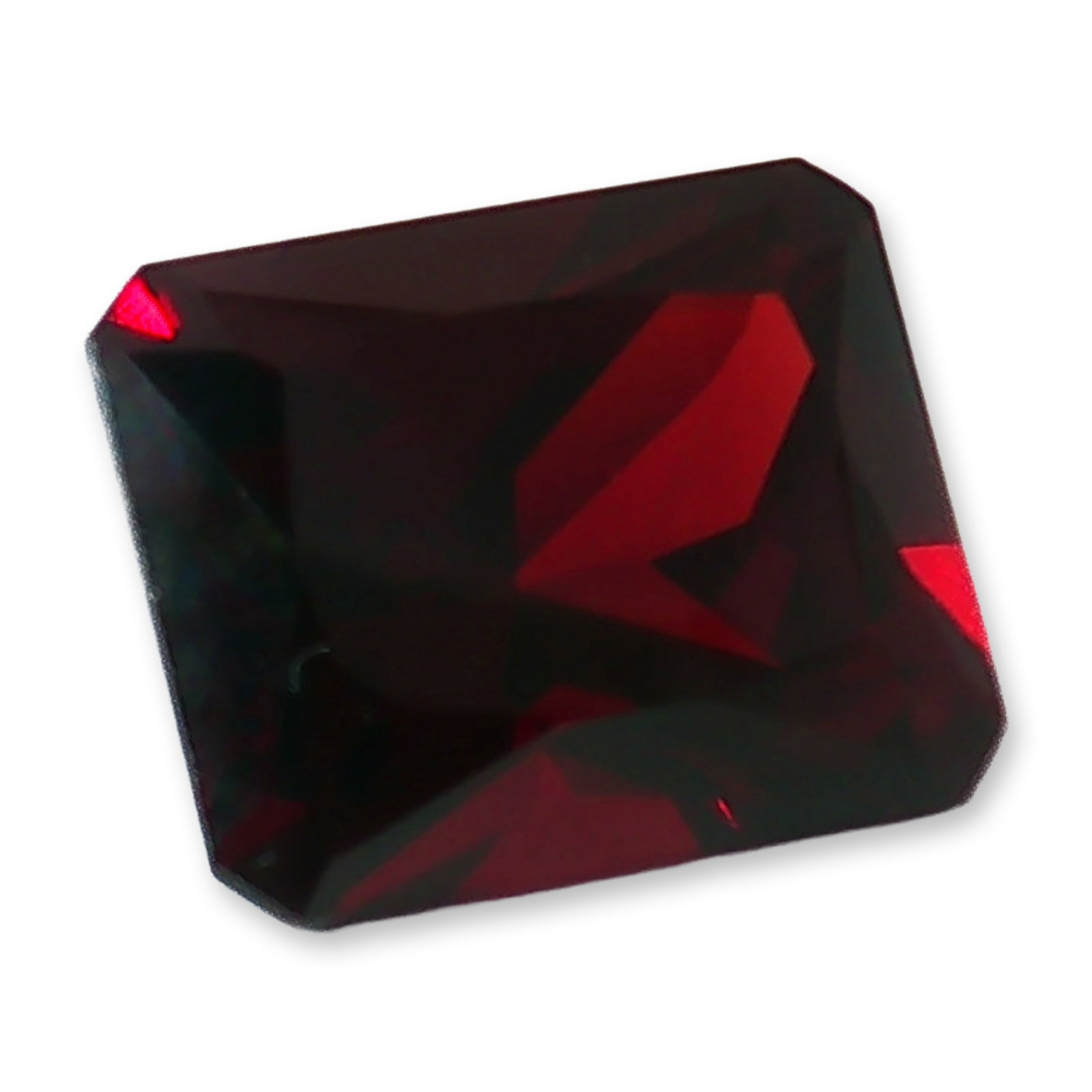 Rectangular Cut Red Garnet Loose Gemstone: Loose red garnet gemstone featuring a rectangular cut with clipped corners. A deep, rich red hue defines the stone, showcasing a dark crimson body color through broad facets. The unmounted gem