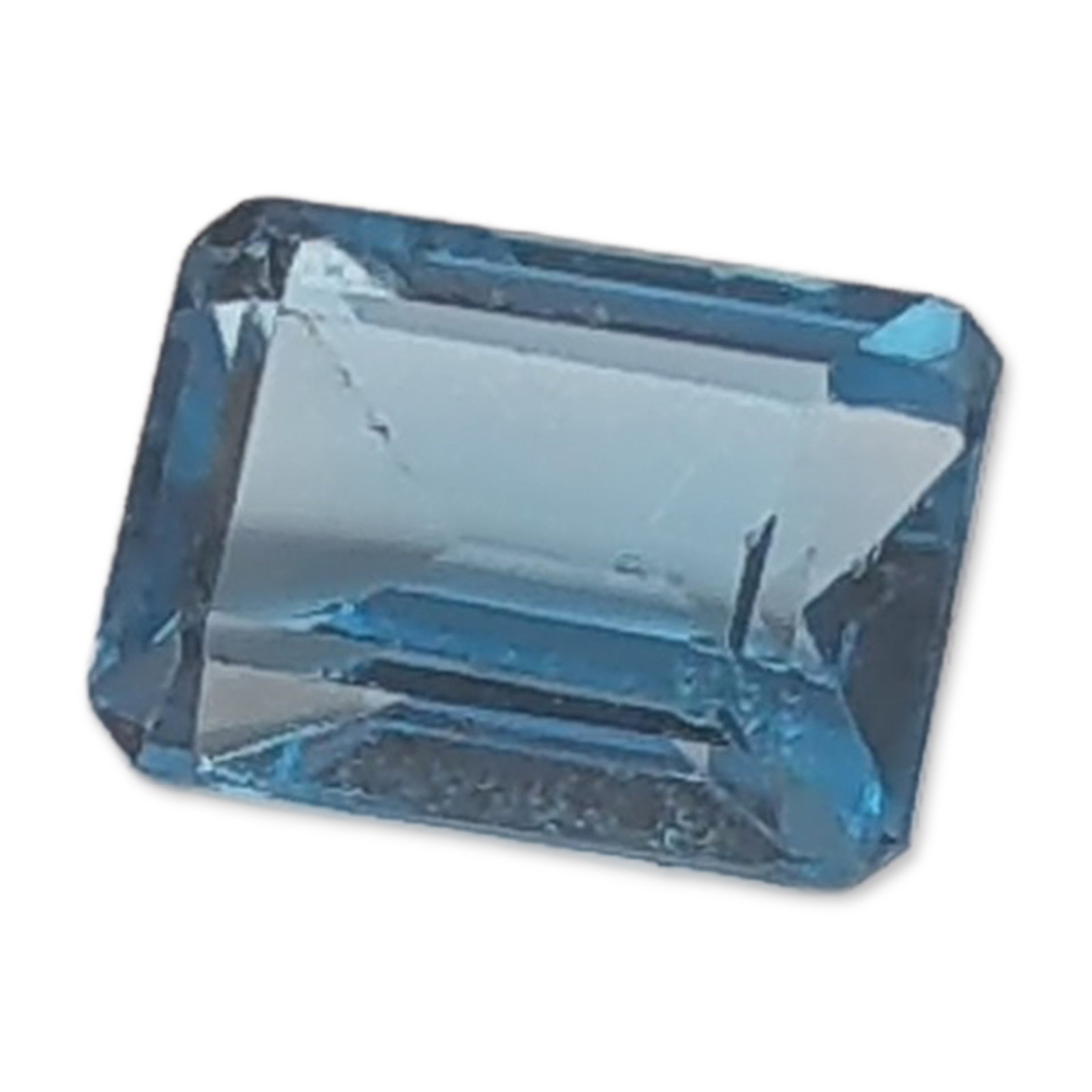 Emerald Cut Blue Topaz Gemstone: Emerald cut loose Topaz gemstone. The stone features a transparent medium blue tone, Rectangular step cut with crisp facet junctions. Weight: 1.5 ct Length: 7.0 mm. Dimensions: 7.0 mmL x 7.0mm