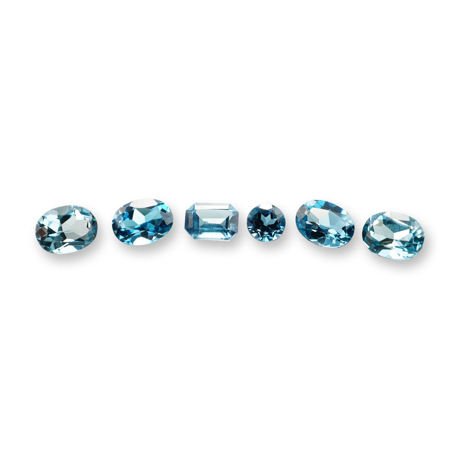 6pc London Blue Topaz Gemstones: Grouping of 6 London Blue Topaz stones. London blue topaz is a highly sought-after gemstone known for its deep, inky blue hue with subtle greenish or grayish undertones. Its calming blue color reduces