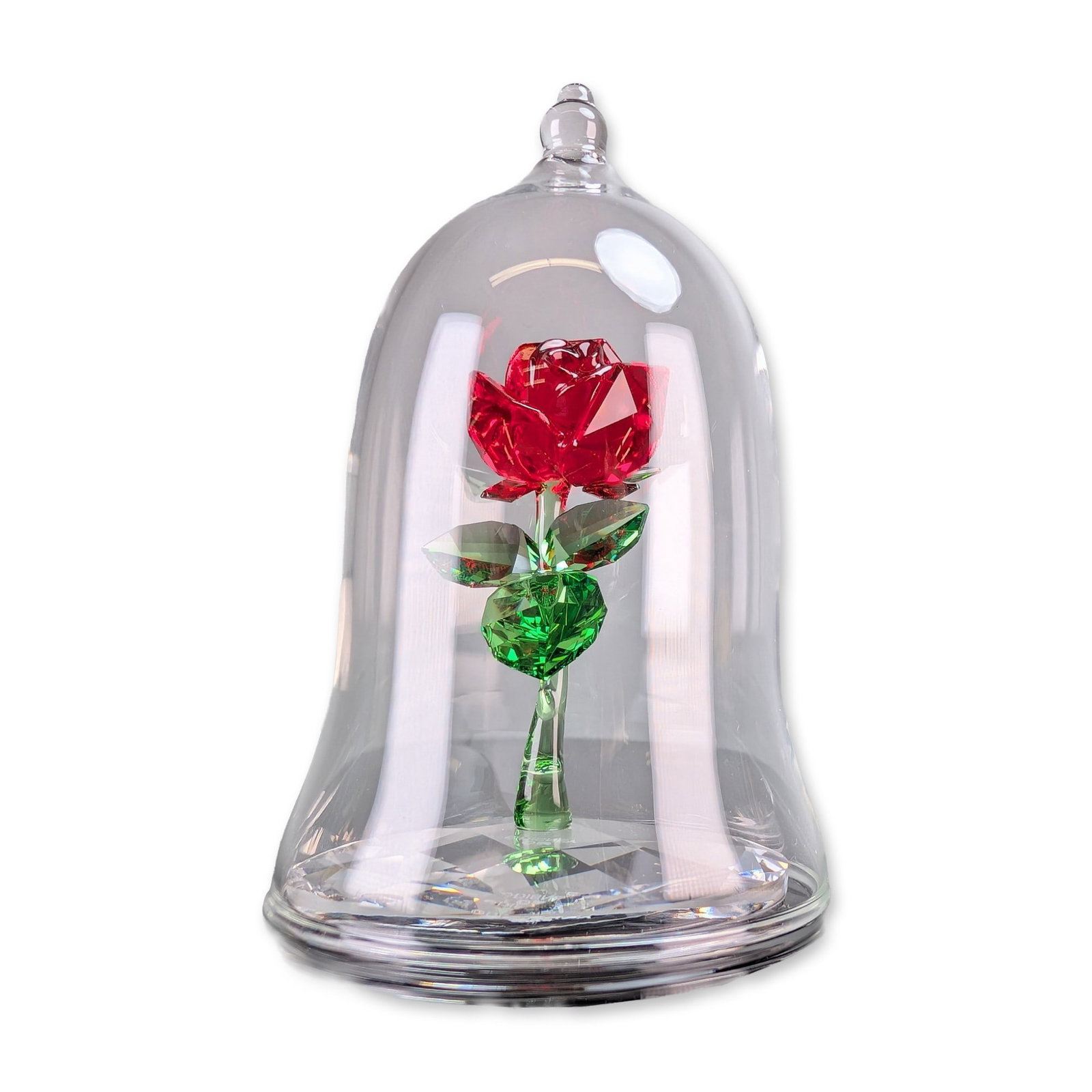 Swarovski Disney Beauty and the Beast Enchanted Rose Figurine: Swarovski Disney collection faceted crystal figurine titled Enchanted Rose representing the iconic rose in the movie Beauty and the Beast. The piece features a red crystal rose bloom on a green crysta