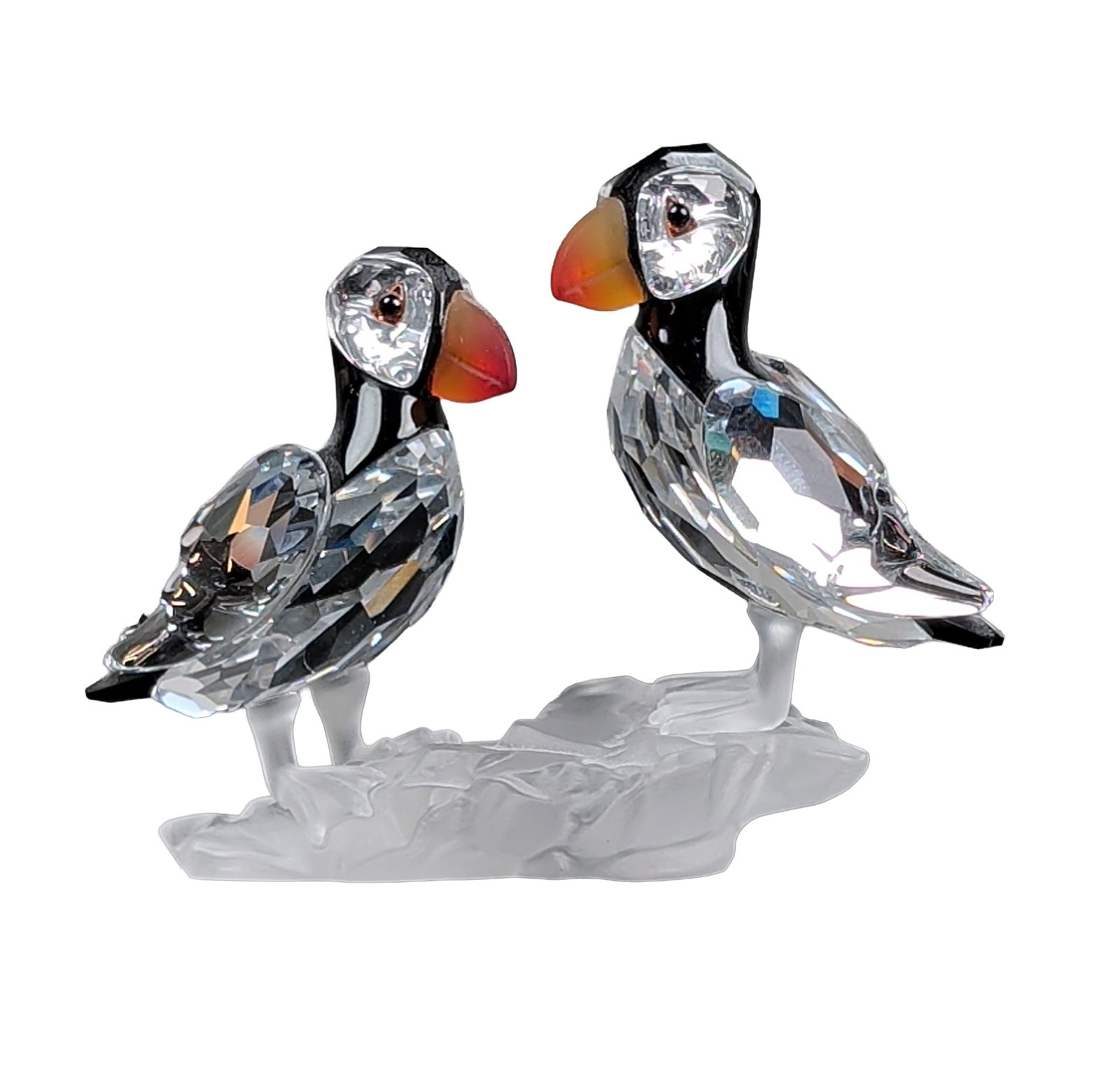 Swarovski Silver Crystal Puffin Pair Figurine: Swarovski Silver Crystal figurine depicting a pair of puffins. The birds are constructed from faceted clear lead crystal with jet black crystal detailing on the heads and tails. Each bird features a f