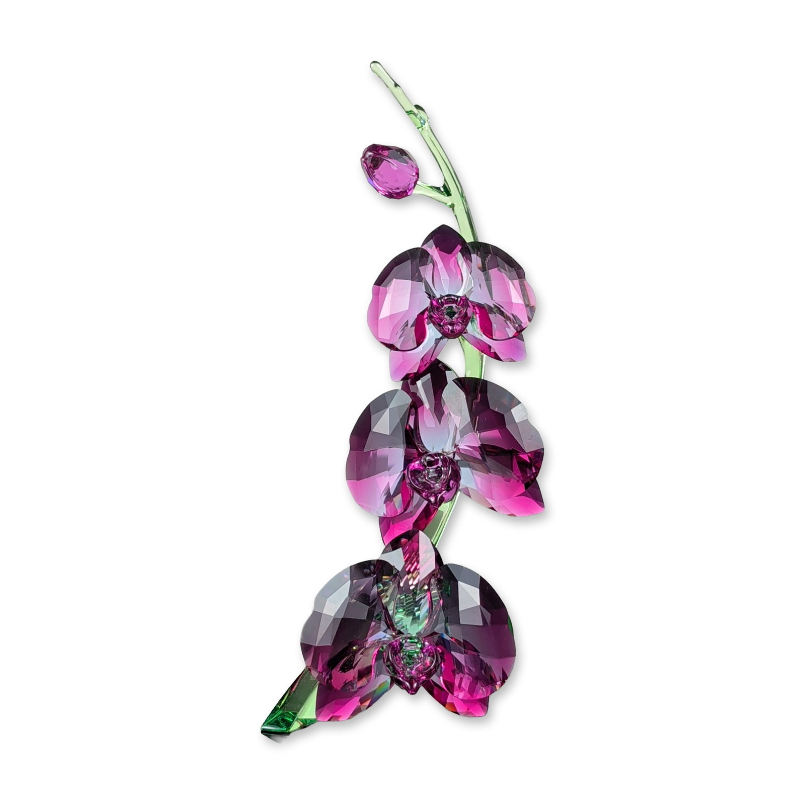Swarovski Crystal Fuchsia Orchid Figurine: Swarovski orchid figurine from the Crystal Flowers series, model number 43561. The piece is crafted from multi-faceted crystal with three blossoms in fuchsia and purple hues set on a light green cryst