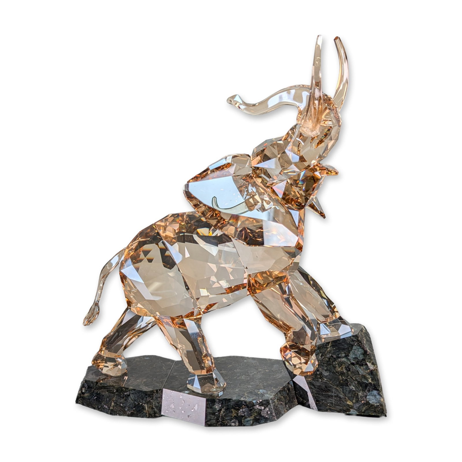 Swarovski Soulmates Light Sand Crystal Elephant Sculpture: Swarovski Soulmates collection elephant sculpture in Light Sand faceted crystal. The figure is modeled in a dynamic pose with its trunk raised and one front leg stepping onto a faceted natural stone b