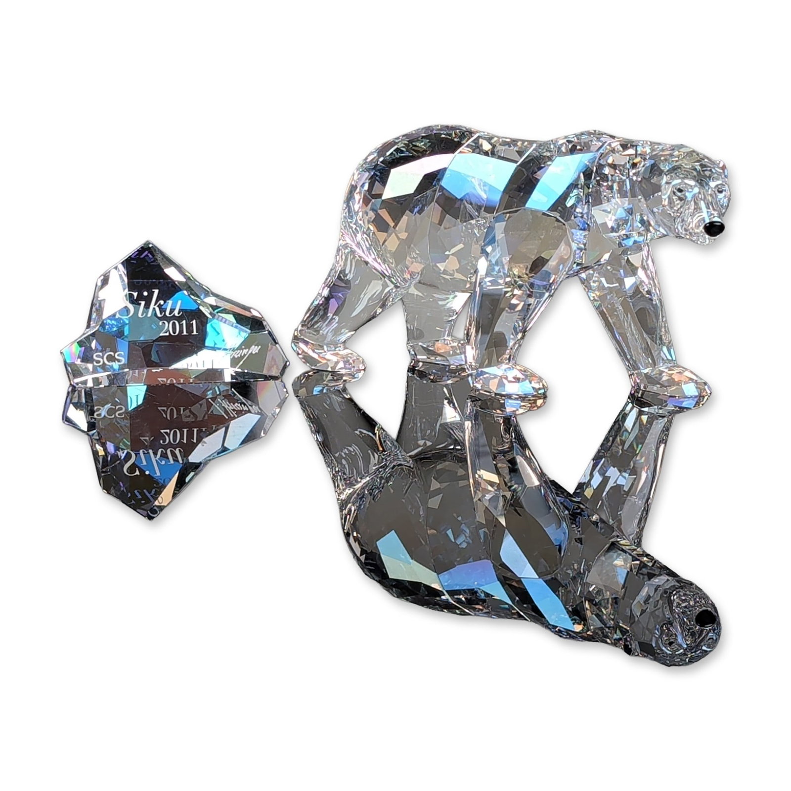 Swarovski SCS 2011 Annual Edition Siku Polar Bear Figurine with Plaque: Swarovski crystal figurine set featuring the SCS 2011 Annual Edition Siku Polar Bear. The bear is modeled in a walking stance, constructed of faceted clear crystal with jet crystal eyes and a jet crys